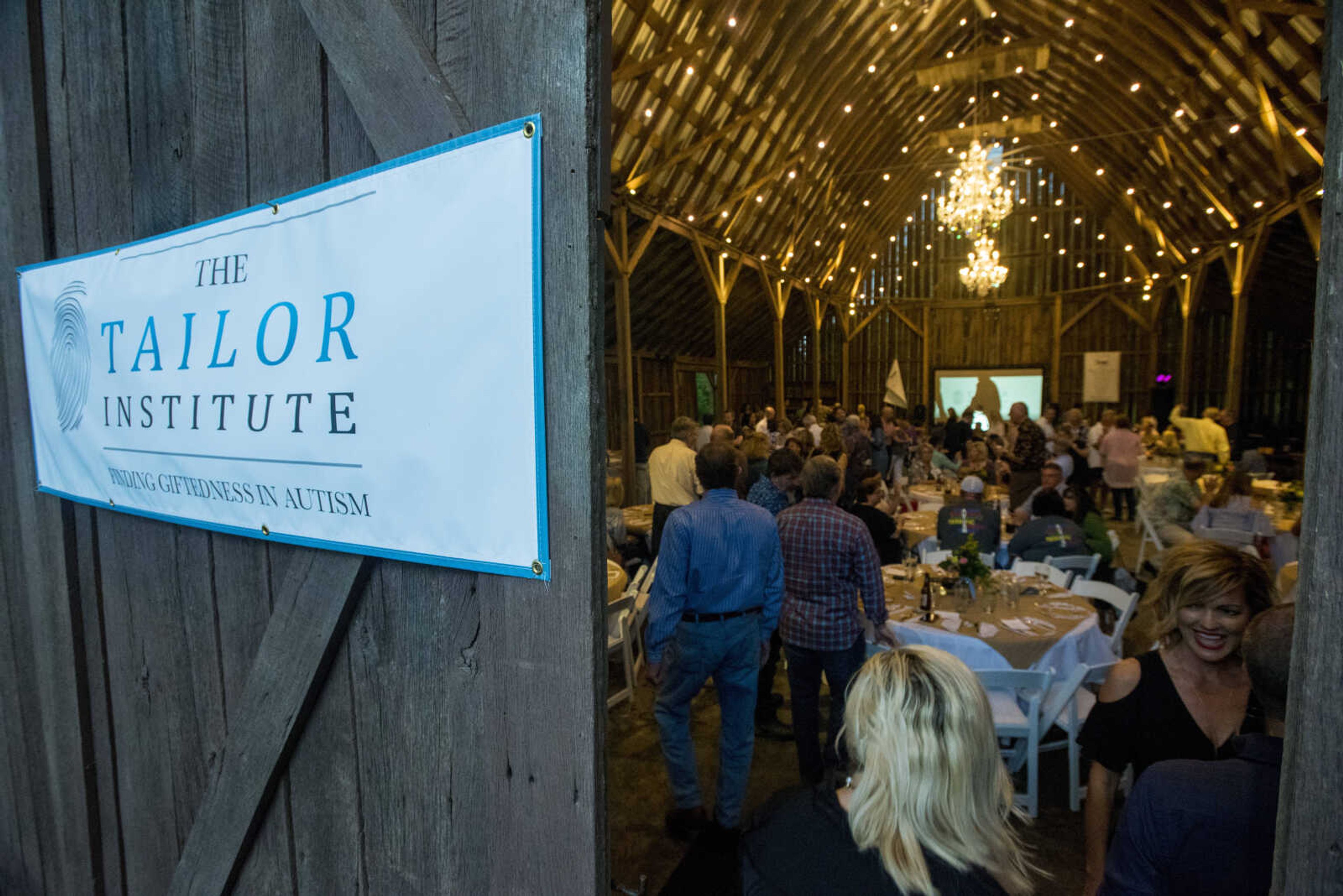 The barn at Rusted Route Farms fills with guests as a thunderstorm approaches on April 29, 2017 during a Swine & Dine pig roast benefiting The Tailor Institute.