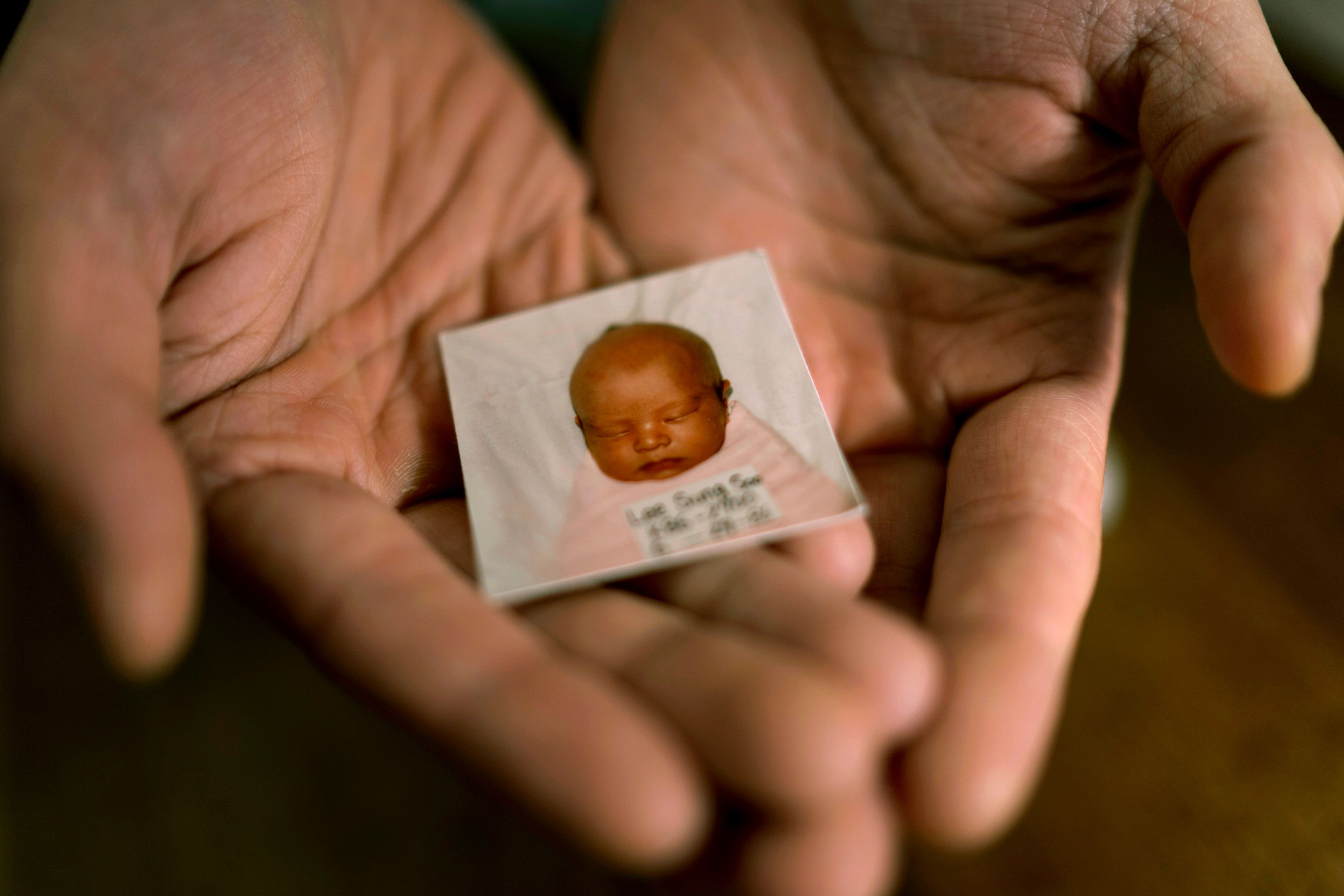 Robert Calabretta holds his baby photo from before he was adopted out of South Korea to a family in the United States, Thursday, Feb. 15, 2024, at his apartment in New York. (AP Photo/David Goldman)