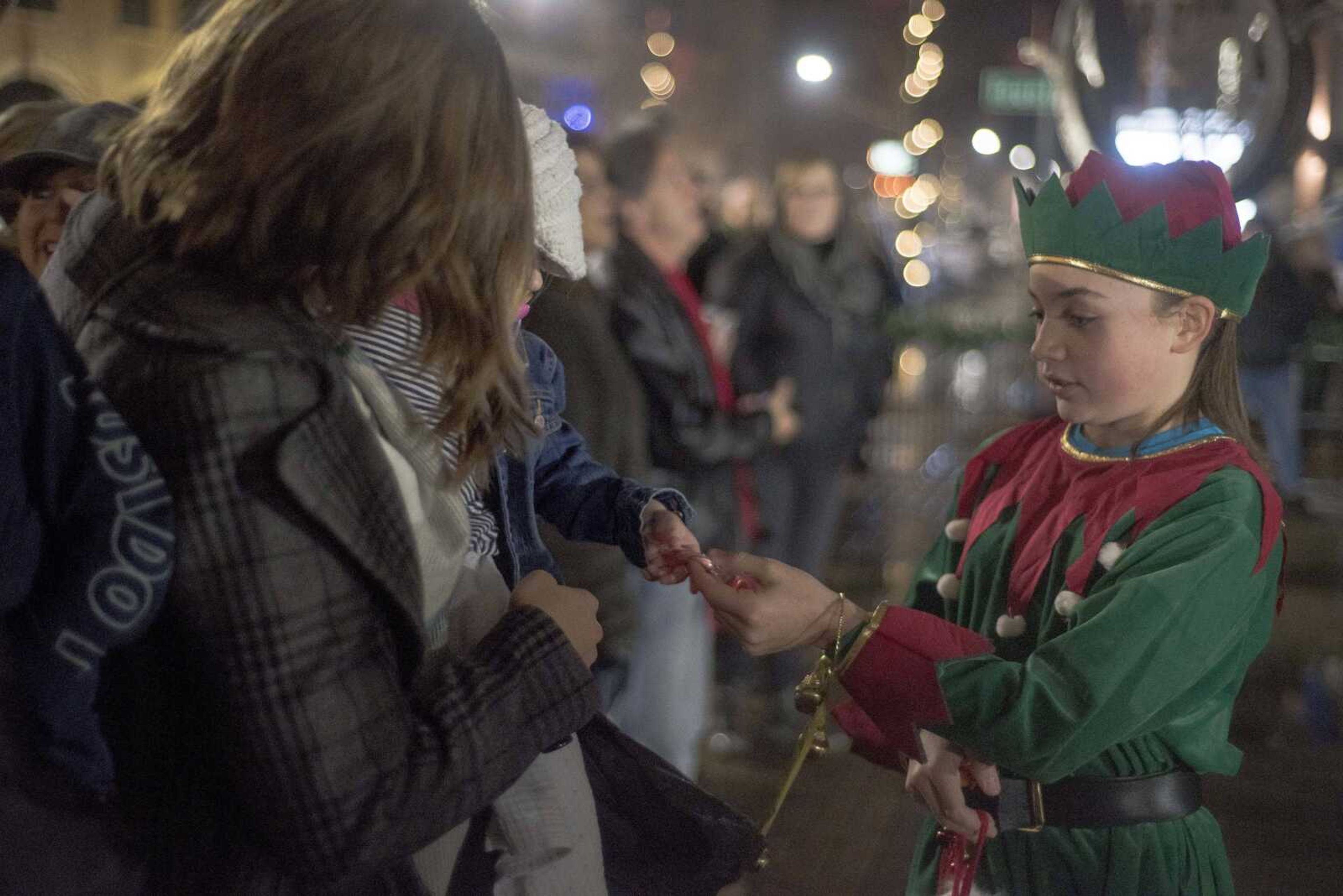 Grayson Maurer, dressed as an elf, distributes candy during the inaugural Christmas tree lighting hosted by Old Town Cape Friday, Nov. 29, 2019, at the Vasterling Suites in Cape Girardeau.