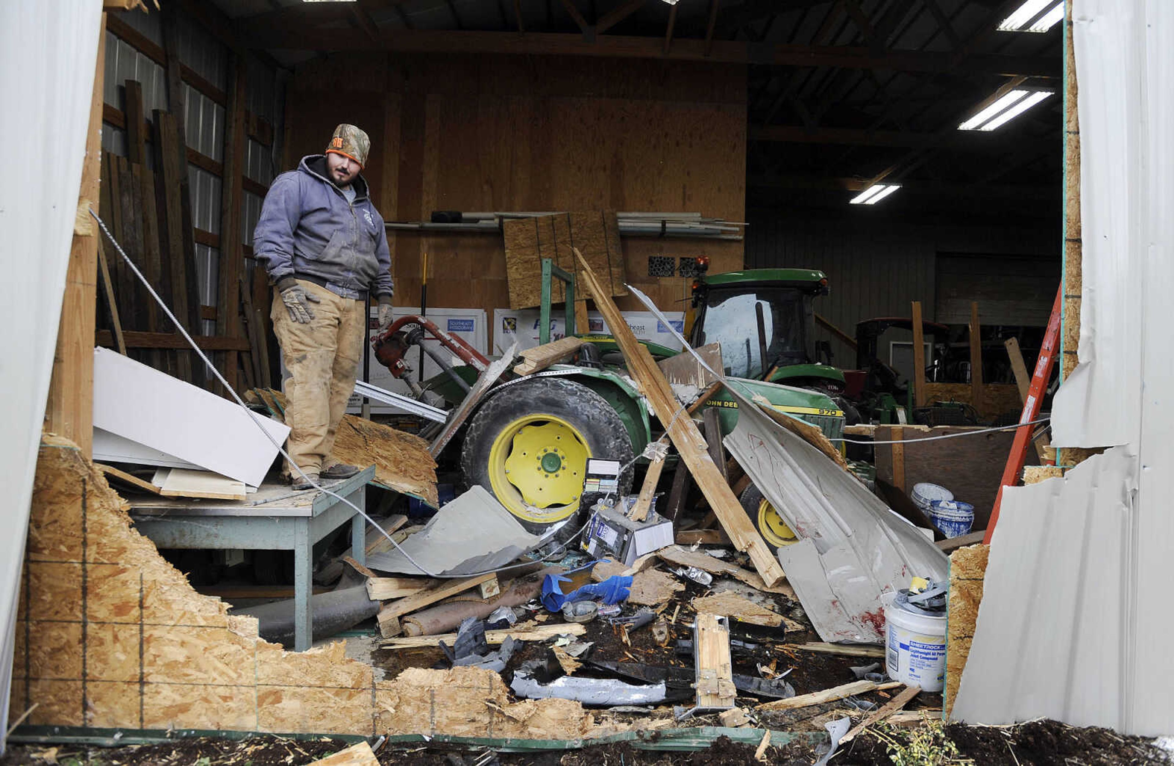 LAURA SIMON ~ lsimon@semissourian.com

Elvin Stone looks over debris stretched across a gap left behind by a sedan that crashed through the wall of an equipment shed at the Shawnee Park Sports Complex, Monday, Jan. 25, 2016, in Cape Girardeau. The vehicle crashed through the wall Sunday night, coming to rest on its nose. Members of the Cape Girardeau Parks and Recreation Department were working on a placing a temporary wall over the hole.