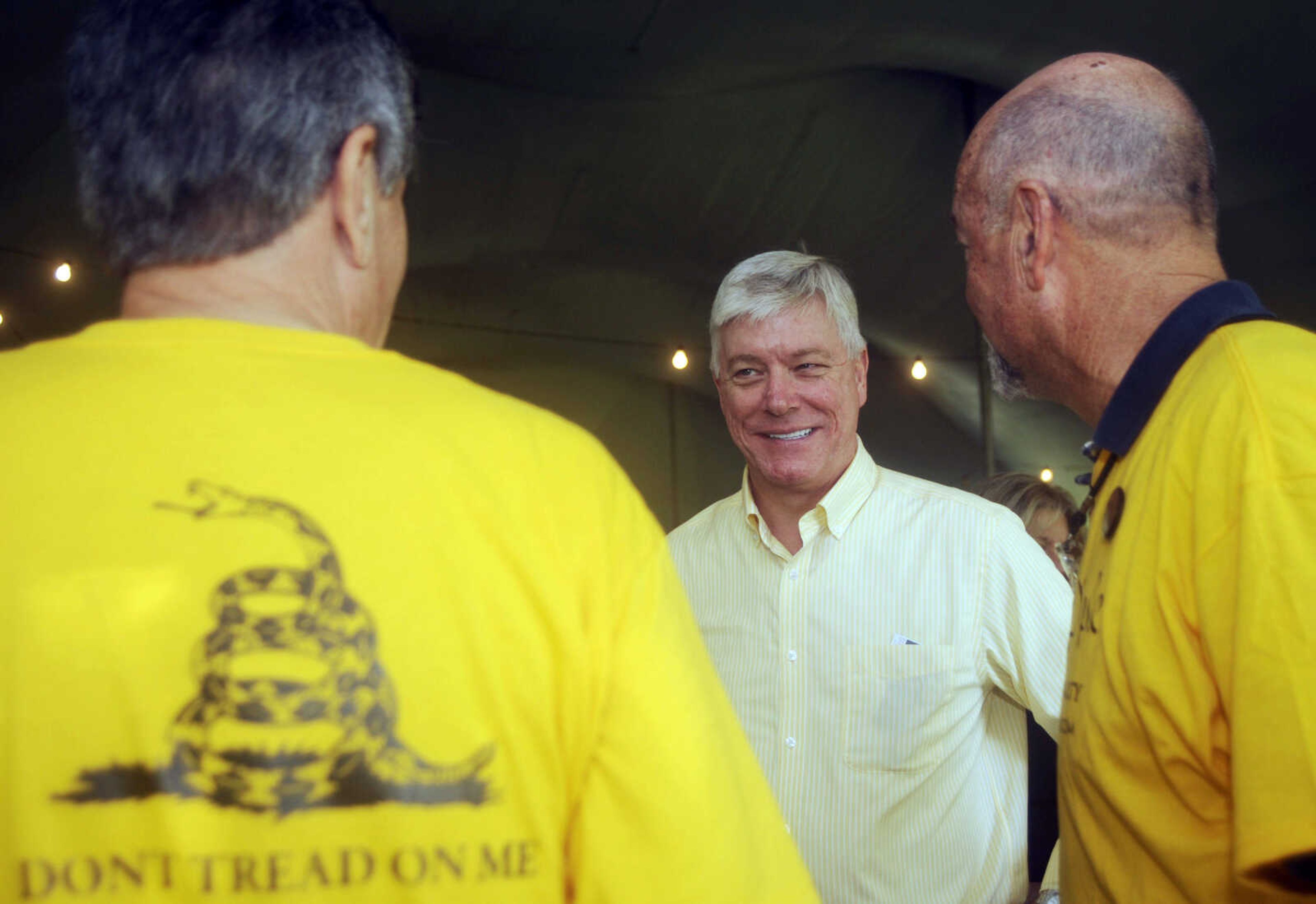 Lt. Gov. Peter Kinder, center, talks with Bill Pierce, of Lebanon, Mo., left, and Herb Brownell, of Linn Creek, Mo., right, as they all wait in a serving line at the Missouri State Fair Governor's Ham Breakfast Thursday morning, Aug. 18, 2011, in Sedalia, Mo. A former exotic dancer claims Kinder made her uncomfortable during visit's to an adult club during mid-1990s, and, earlier this year, offered to let her stay at a condo paid for by his campaign. Kinder, a Republican from Cape Girardeau, Mo., has denied the allegations and is expected to run for governor in 2012 against Democratic incumbent Jay Nixon.(AP Photo/Kelley McCall)