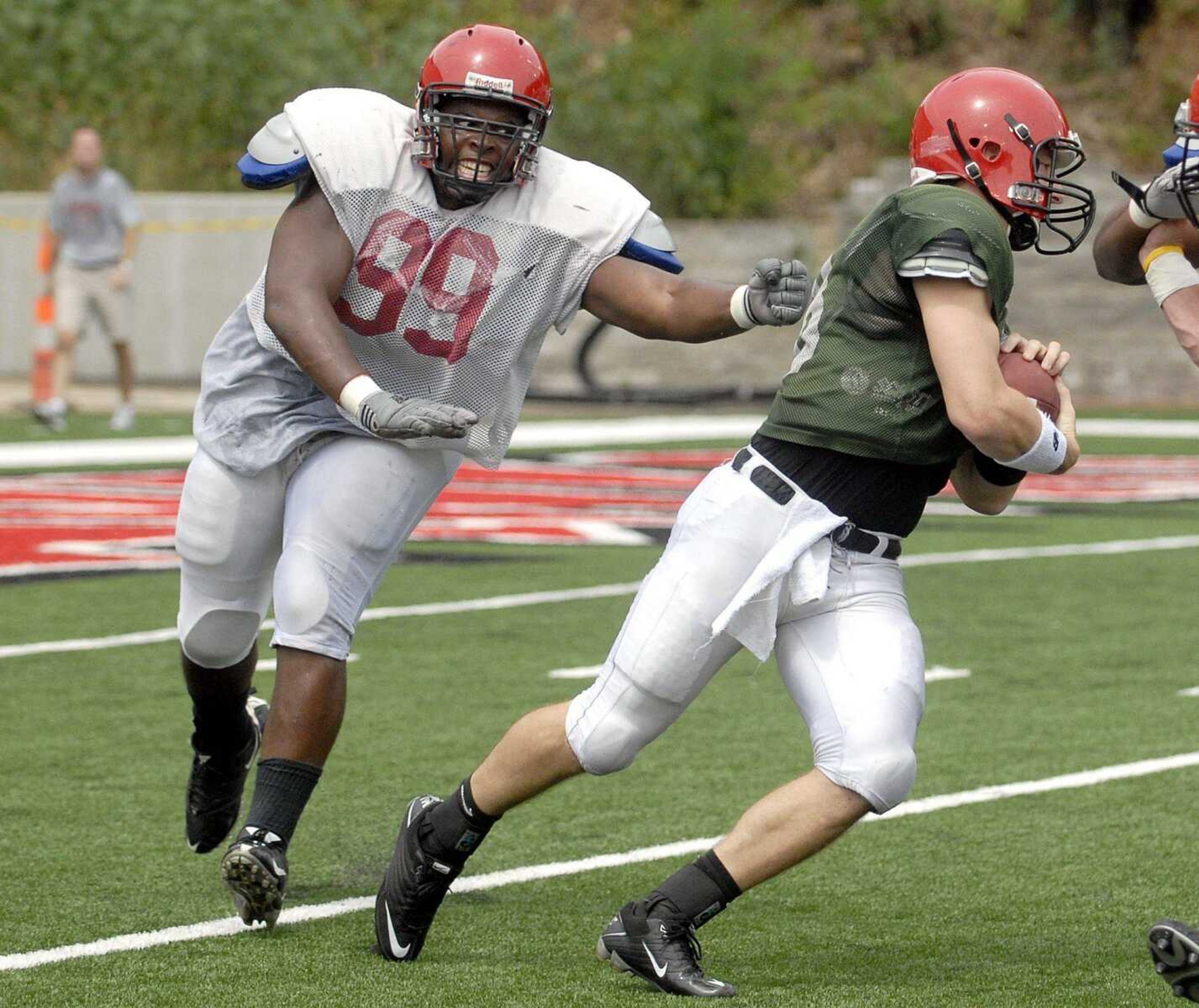 Southeast defensive tackle Quinn Perry tries to take down quarterback Matt Scheible Saturday, August 20, 2011 during the Redhawks football scrimmage at Houck Stadium. (Laura Simon)