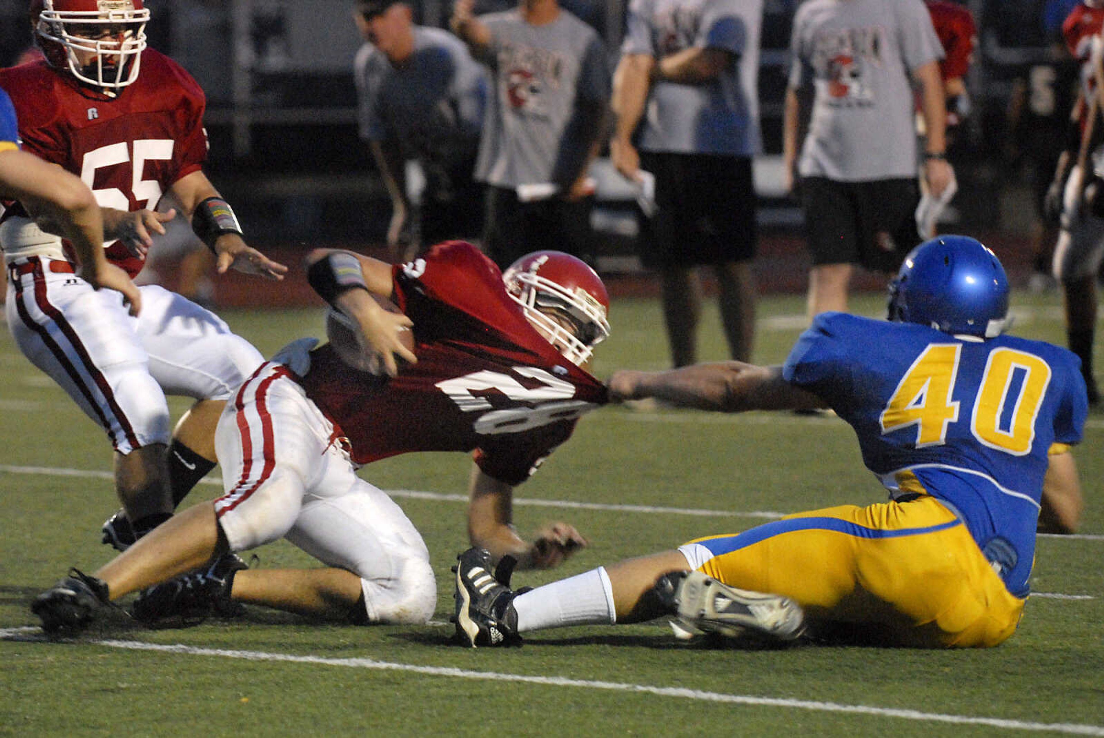 KRISTIN EBERTS ~ keberts@semissourian.com

Jackson's Trent Sizemore gets pulled down by Seckman's Justin Liescheidt, right, as Jackson's Micheal Riney, left, looks on during a jamboree game on Friday, August 20, 2010, at Farmington High School.