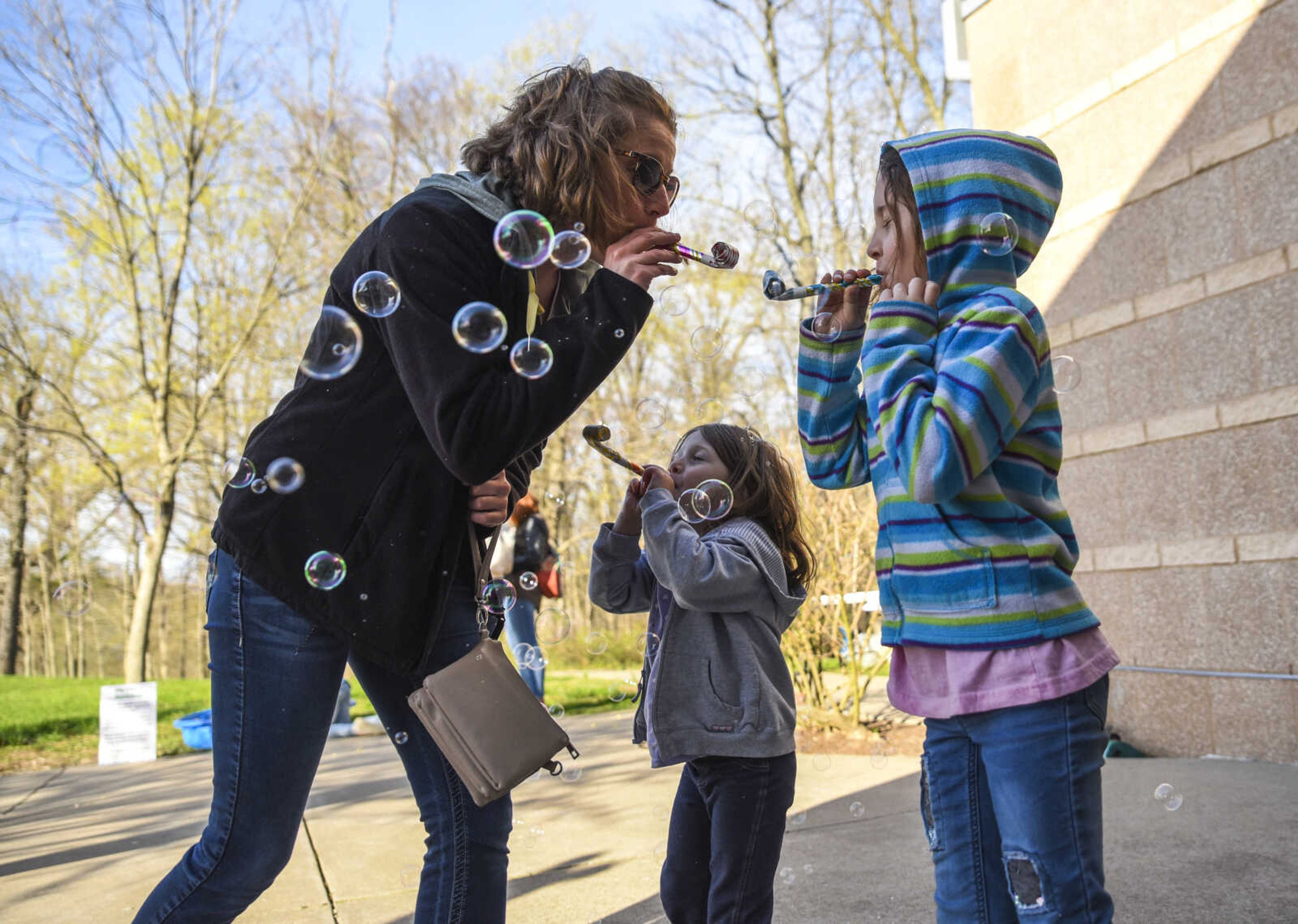 From left, Rebecca Bucher pops bubbles like frogs using party favor toys with her daughters Averie Bruce, 4, and Harper Bruce, 6, during Froggy Friday at the Cape Girardeau Conservation Nature Center Friday, April 20, 2018.