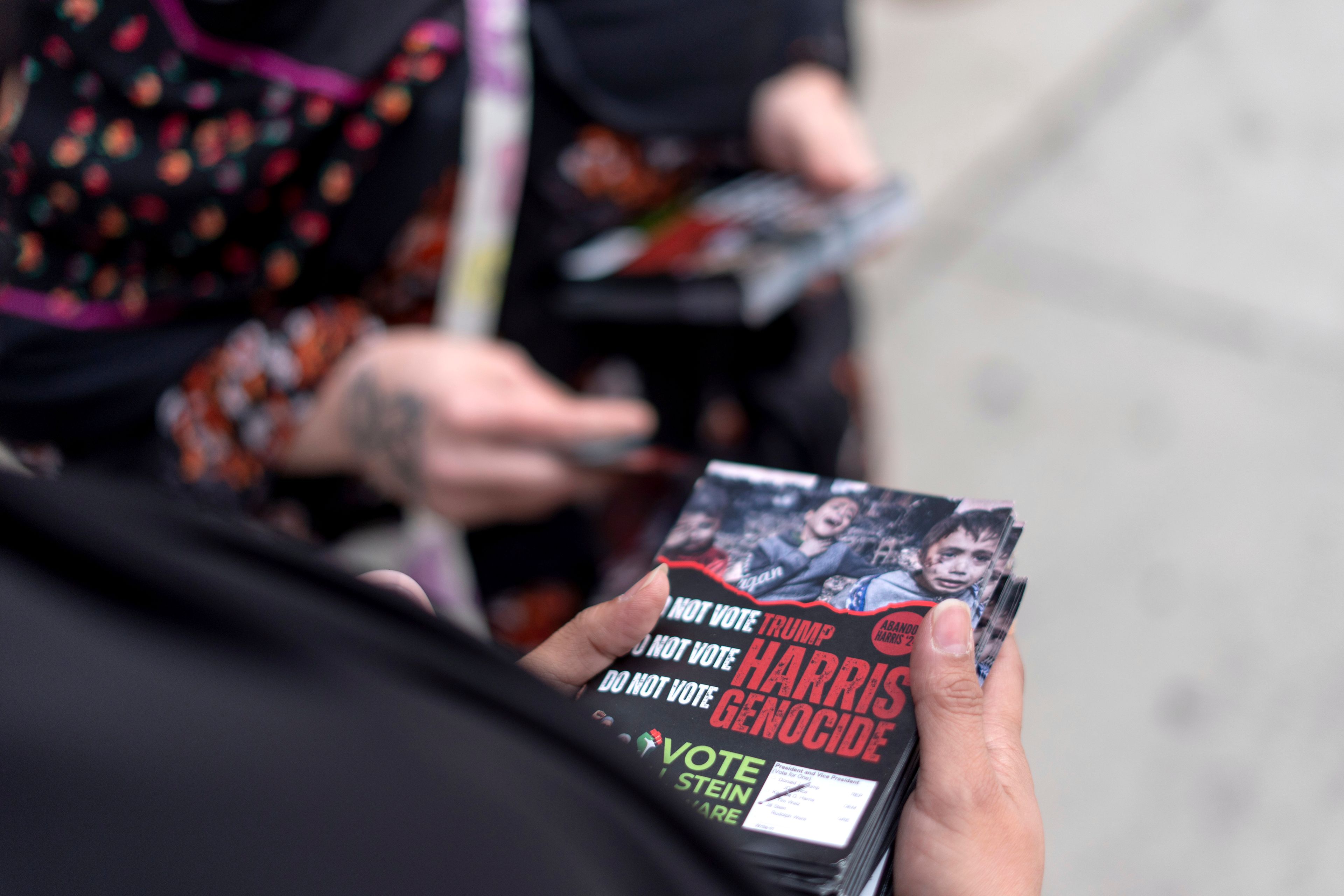 Farah Khan, right, and Chelsey Salama, with the Abandon Harris movement, prepare fliers to hand out to pedestrians encouraging them to vote for Green Party presidential candidate Jill Stein, Monday, Nov. 4, 2024, in Dearborn, Mich., the nation's largest Arab-majority city. (AP Photo/David Goldman)