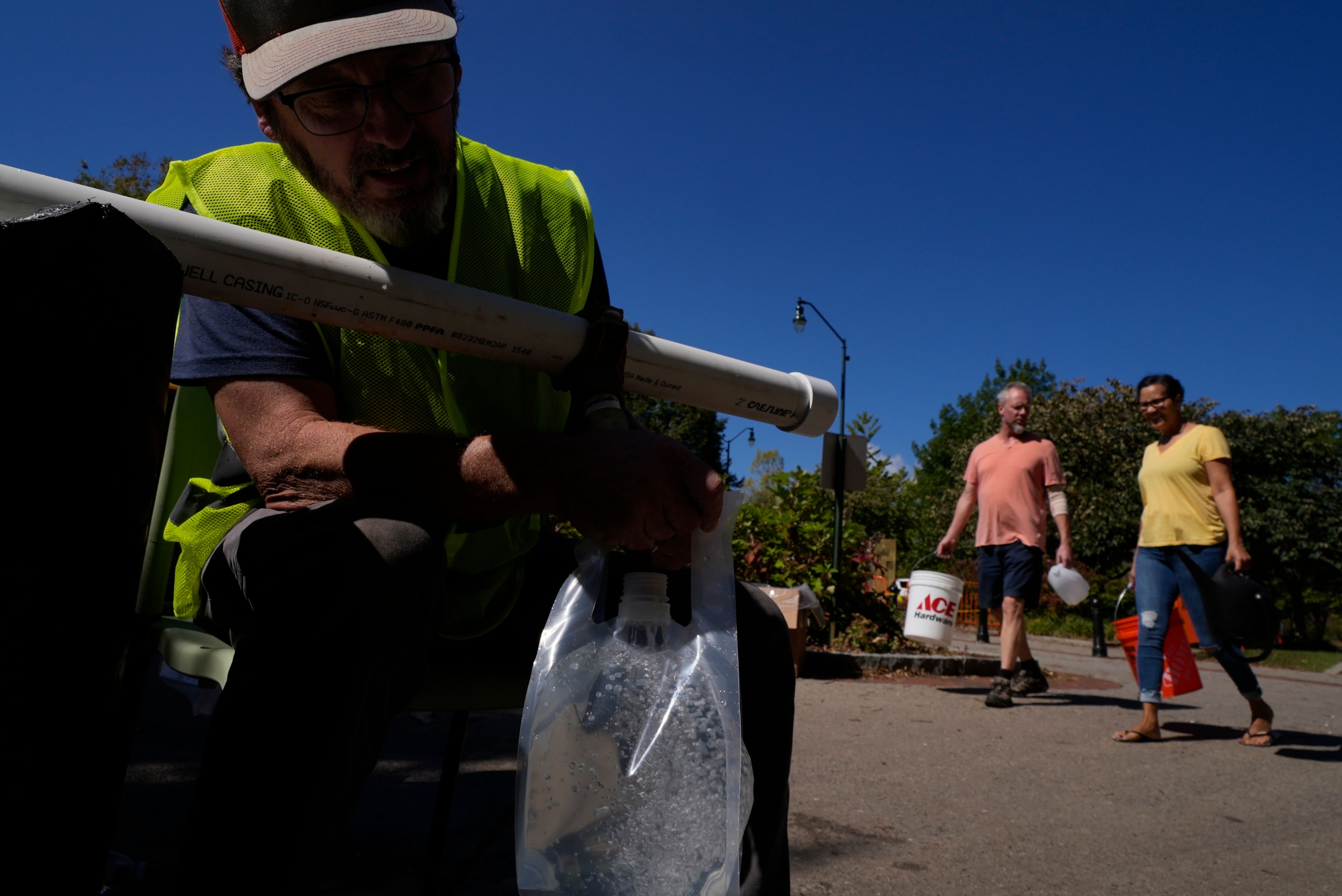 Michael Traister fills a bag of drinking water Thursday, Oct. 3, 2024 in Asheville, North Carolina. (AP Photo/Brittany Peterson)