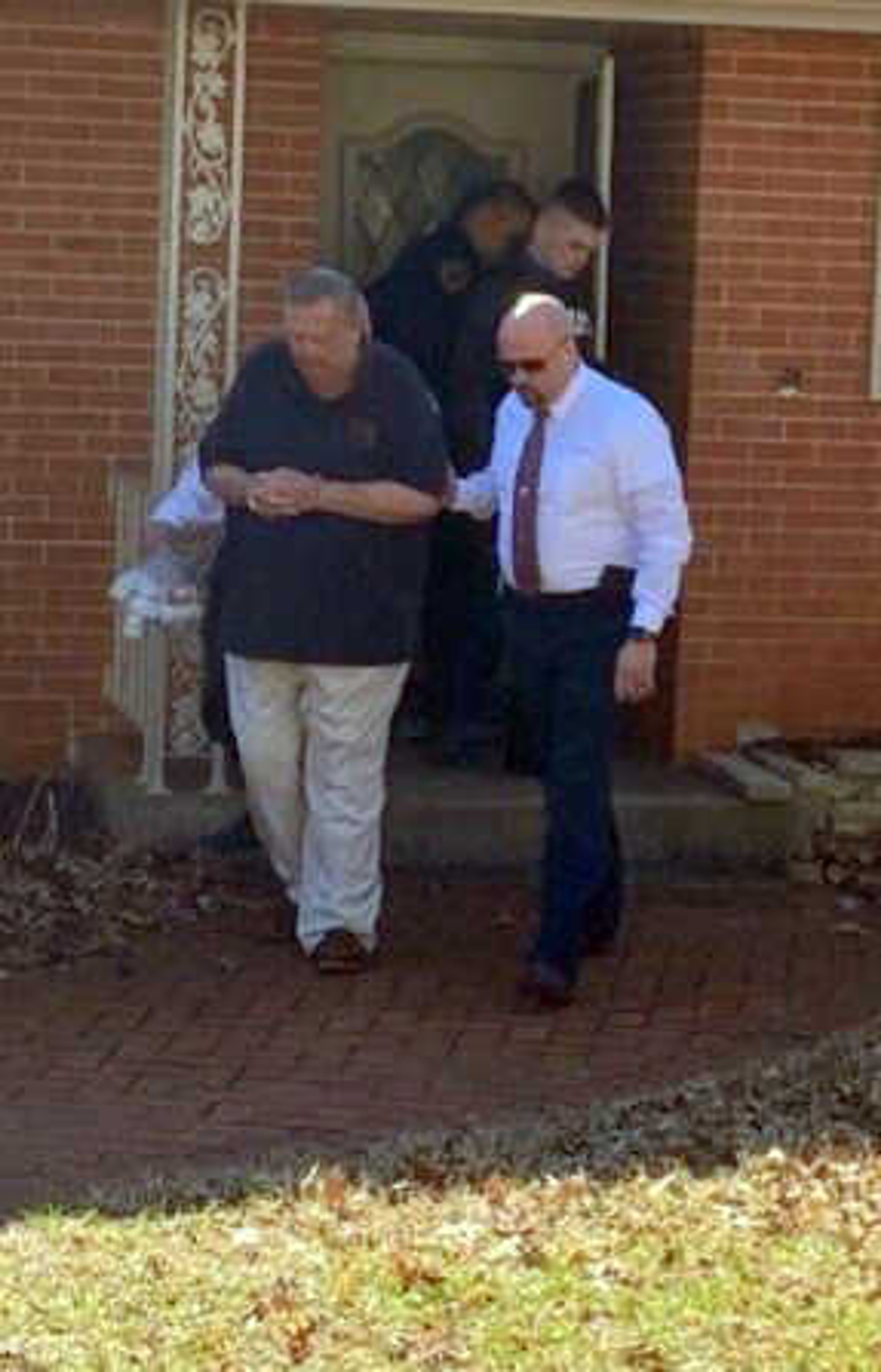 Tim McCoy, right, an investigator with the Stoddard County Prosecuting Attorney's Office, leads Frederick Joseph Lutz out of his Springfield, Missouri, home Wednesday, Feb. 19, 2020, on a warrant charging him with four sexual-related felonies stemming from allegations that occurred while it was a priest in Advance, Missouri, in 2000.