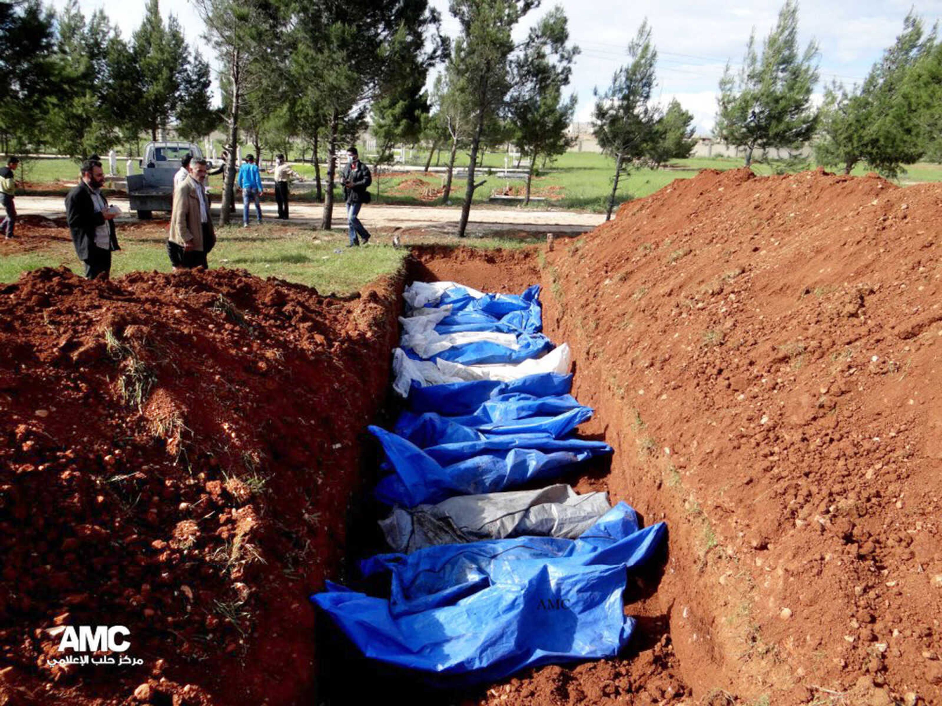 This citizen journalism image provided by Aleppo Media Center AMC which has been authenticated based on its contents and other AP reporting, shows a mass burial of people allegedly killed by Syrian Army snipers, in Aleppo, Syria, Wednesday, April 17, 2013. On Tuesday, the Syrian Red Crescent recovered 31 bodies between the Aleppo neighborhoods of Sakhour and Midan, according to the Aleppo Media Center activist group. The Syrian Observatory for Human Rights also reported the discovery of 31 bodies in the same location. Both groups said the dead had been killed by snipers in recent months, but because of the location of the bodies they couldn't be retrieved for burial until Tuesday. (AP Photo/Aleppo Media Center AMC)