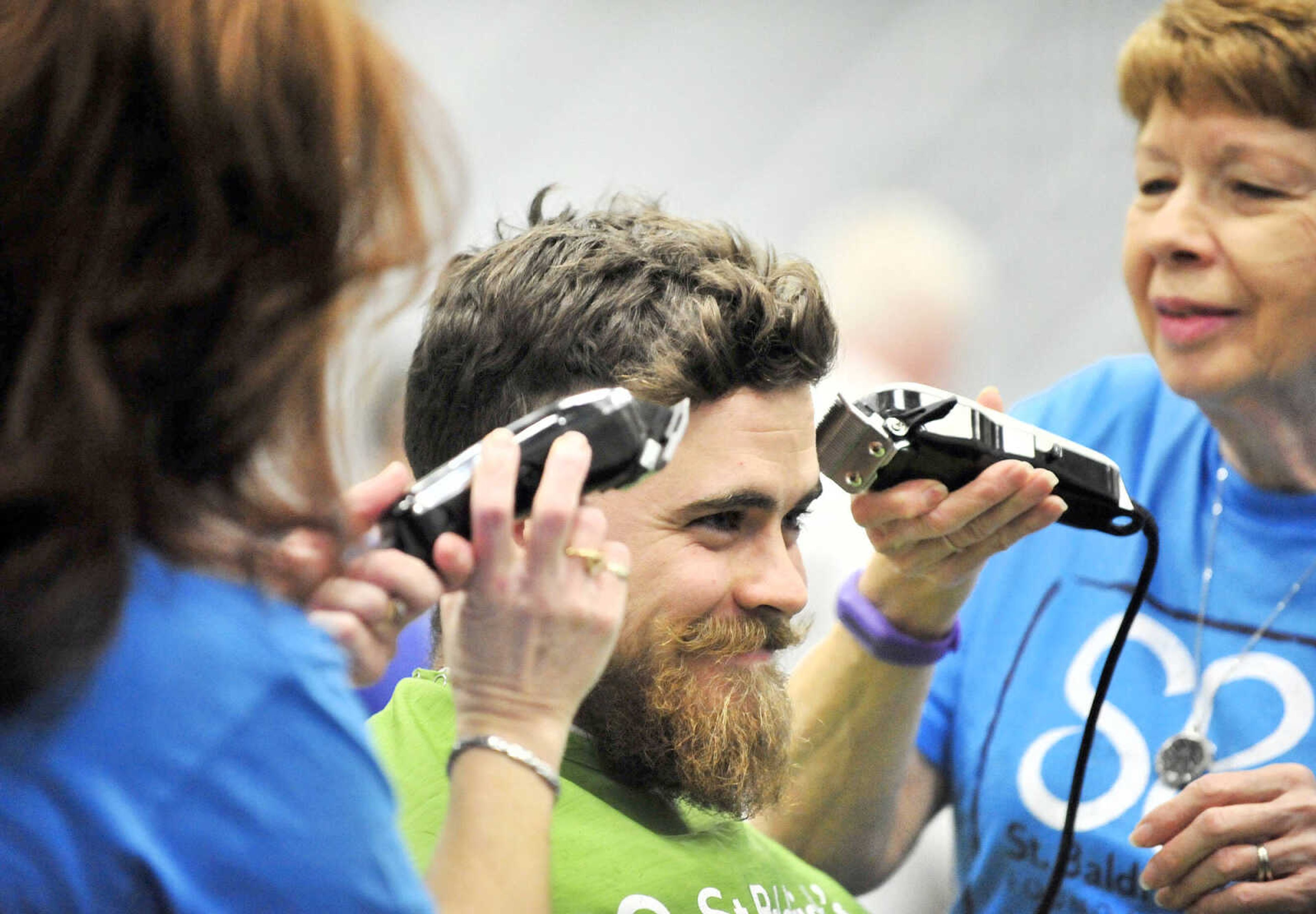 Mother and daughter duo April Whiteside, left, and Jean McLane, right, shave David Mincemeyer's head in unison  on Saturday, March 4, 2017, during the St. Baldrick's Foundation fundraiser at Old Orchard CrossFit in Jackson.