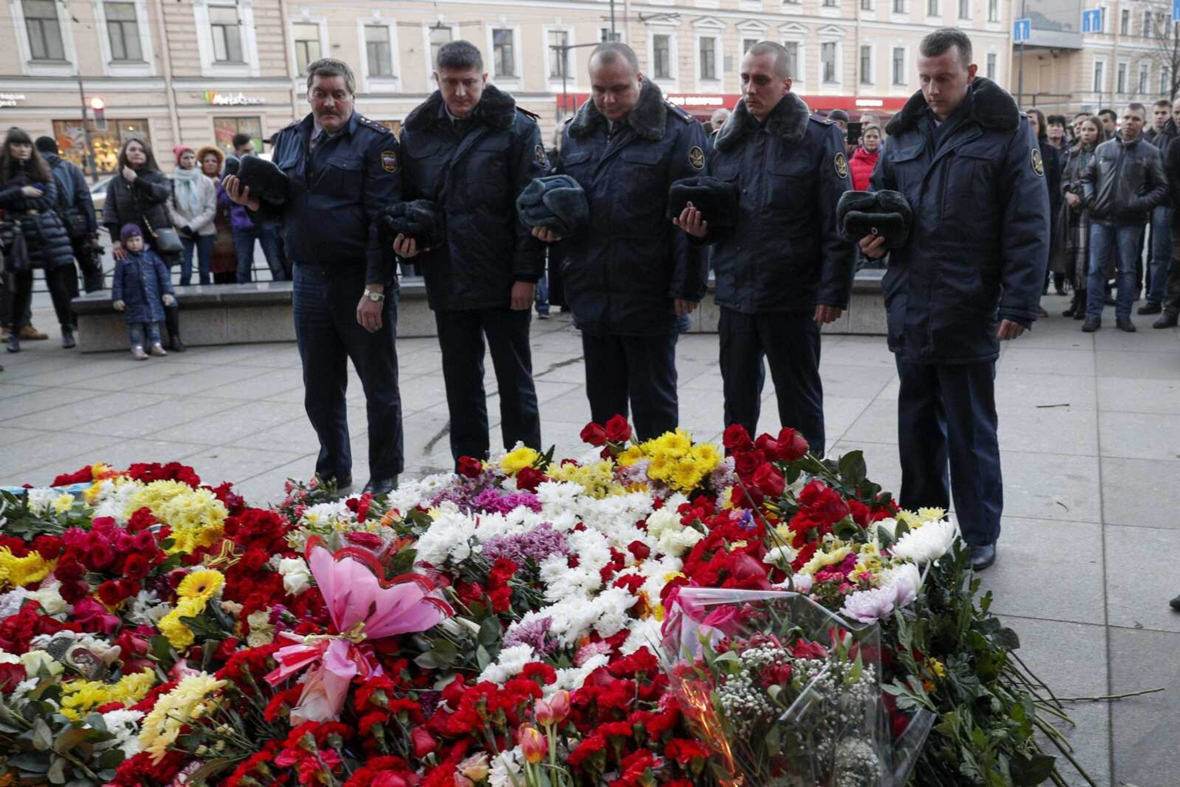 Russian officers of the prison guard pay their respect at a memorial at the Technologicheskiy Institute subway station Tuesday in St. Petersburg, Russia. A terrorist blast on a subway train claimed the lives of 14 people a day earlier.