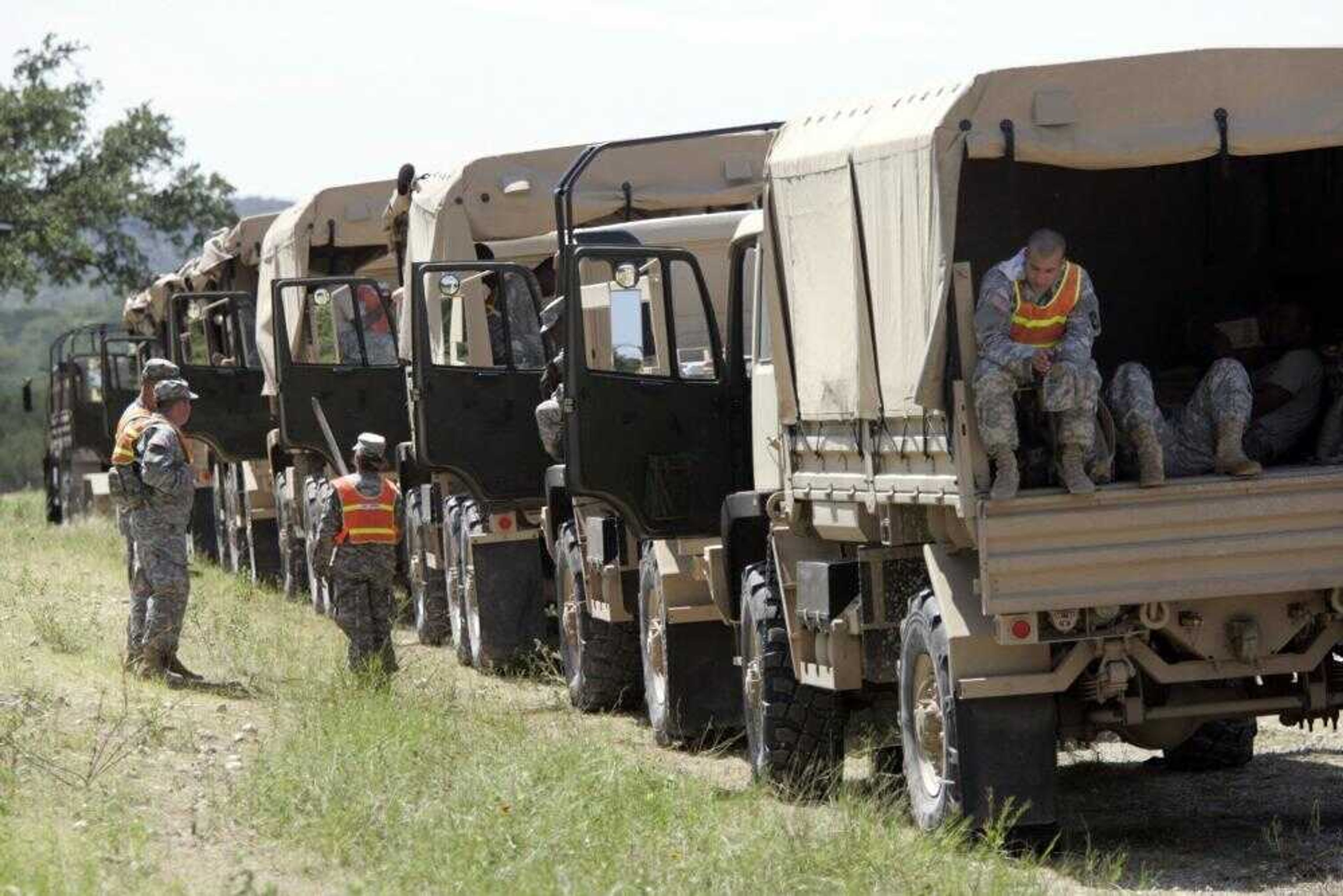 U.S. Army soldiers rested Tuesday alongside a road by a search and rescue staging area for a missing soldier, Sgt. Lawrence G. Sprader, at Fort Hood, Texas. (Tony Gutierrez ~ Associated Press)