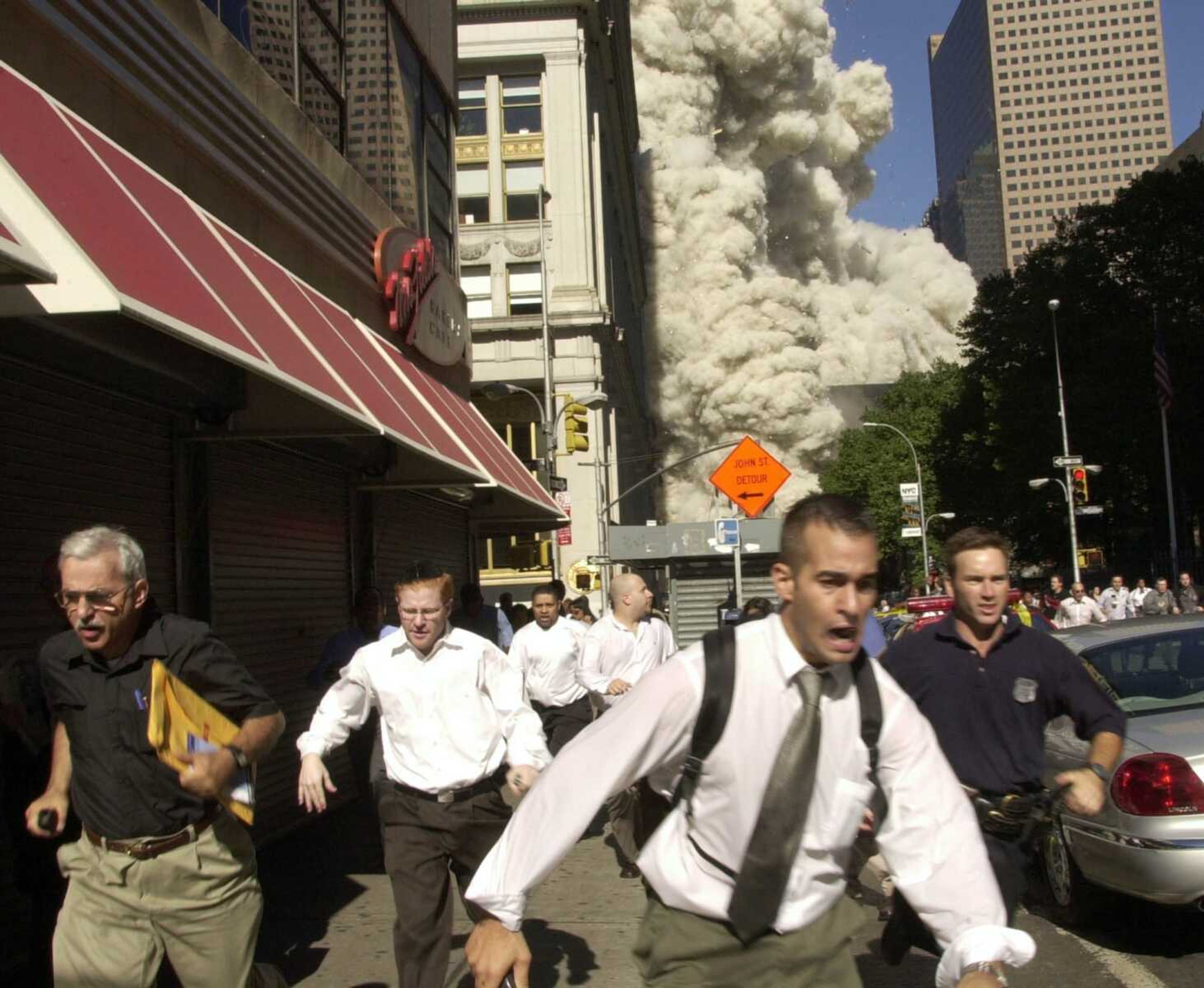 People run from the collapse of one of the twin towers of New York's World Trade Center in this Sept. 11, 2001,  file photo. (AP Photo/FILE/Suzanne Plunkett)