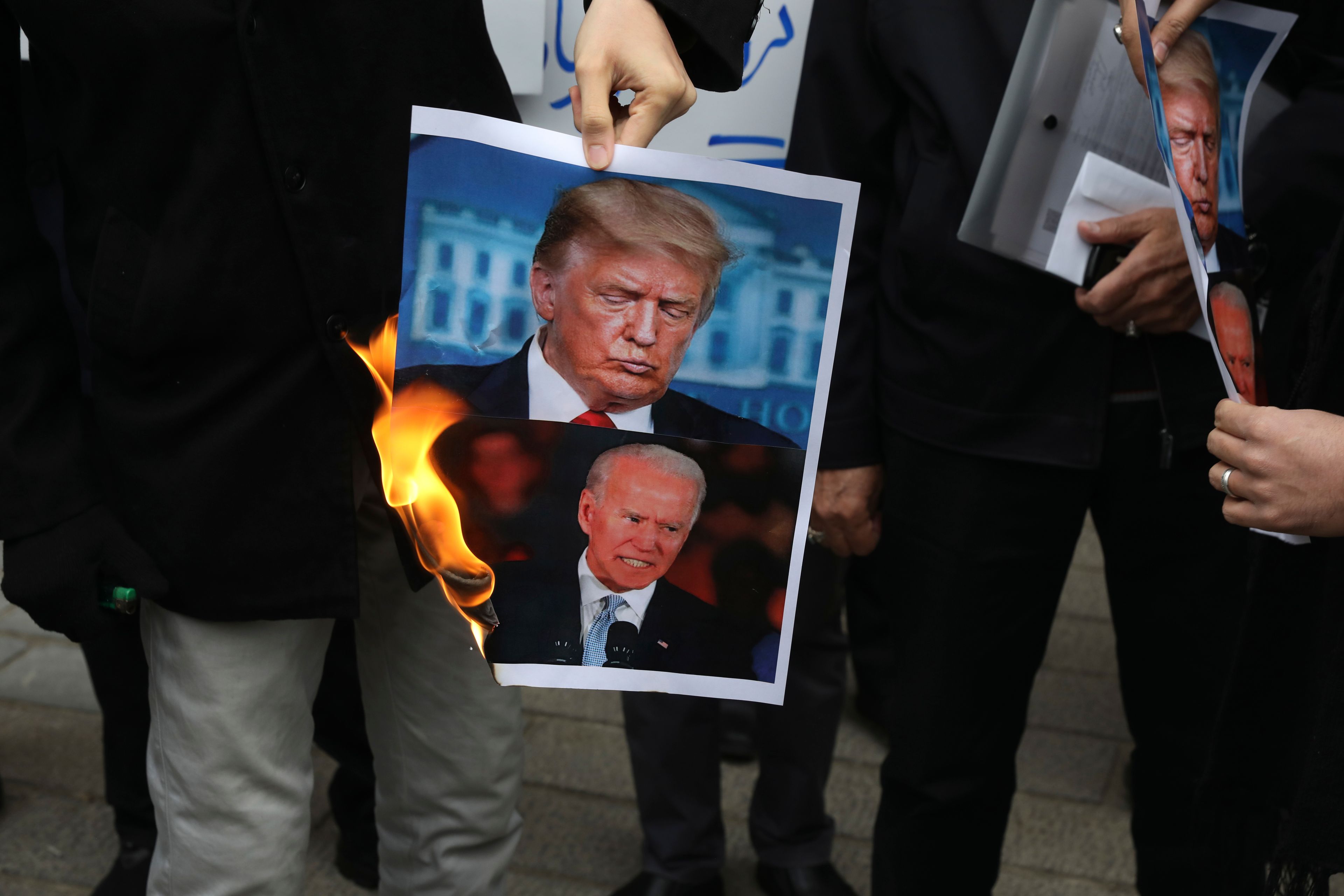 FILE — A group of protesters burn pictures of then-U.S. President Donald Trump, top, and then-President-elect Joe Biden in a gathering in front of Iranian Foreign Ministry on Saturday, Nov. 28, 2020, in Tehran, Iran. (AP Photo/Vahid Salemi, File)