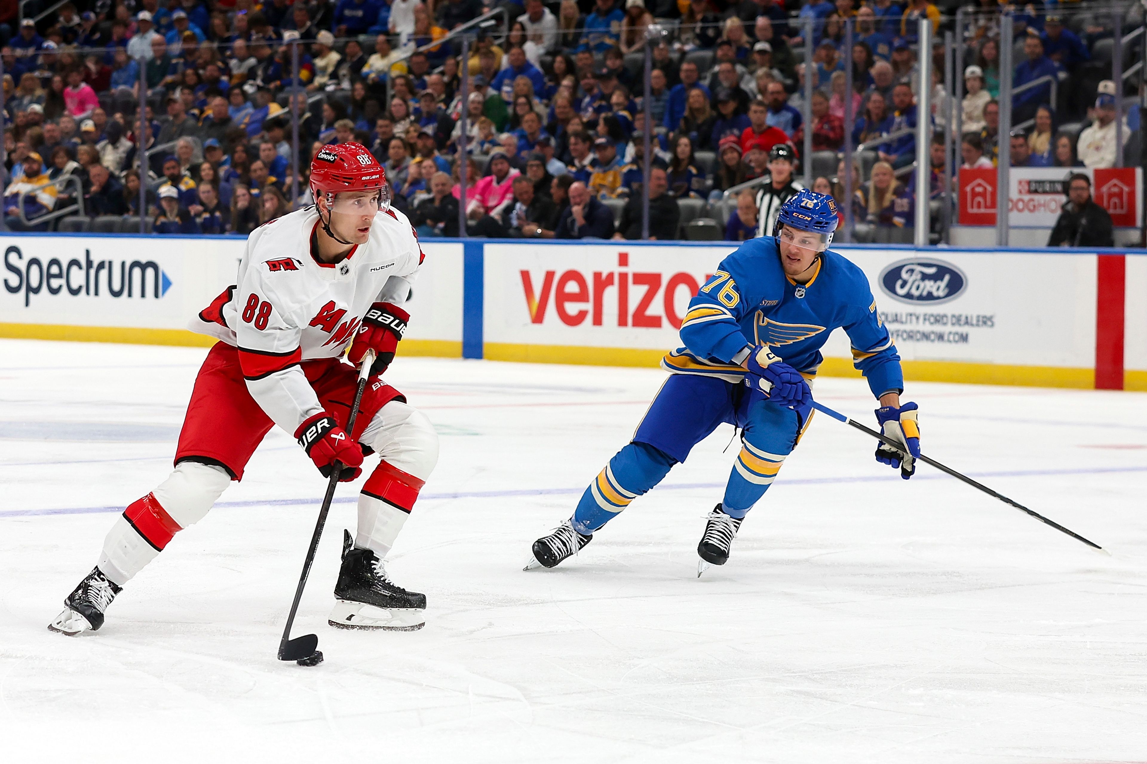 Carolina Hurricanes' Martin Necas (88) controls the puck while under pressure from St. Louis Blues' Zack Bolduc (76) during the first period of an NHL hockey game Saturday, Oct. 19, 2024, in St. Louis. (AP Photo/Scott Kane)