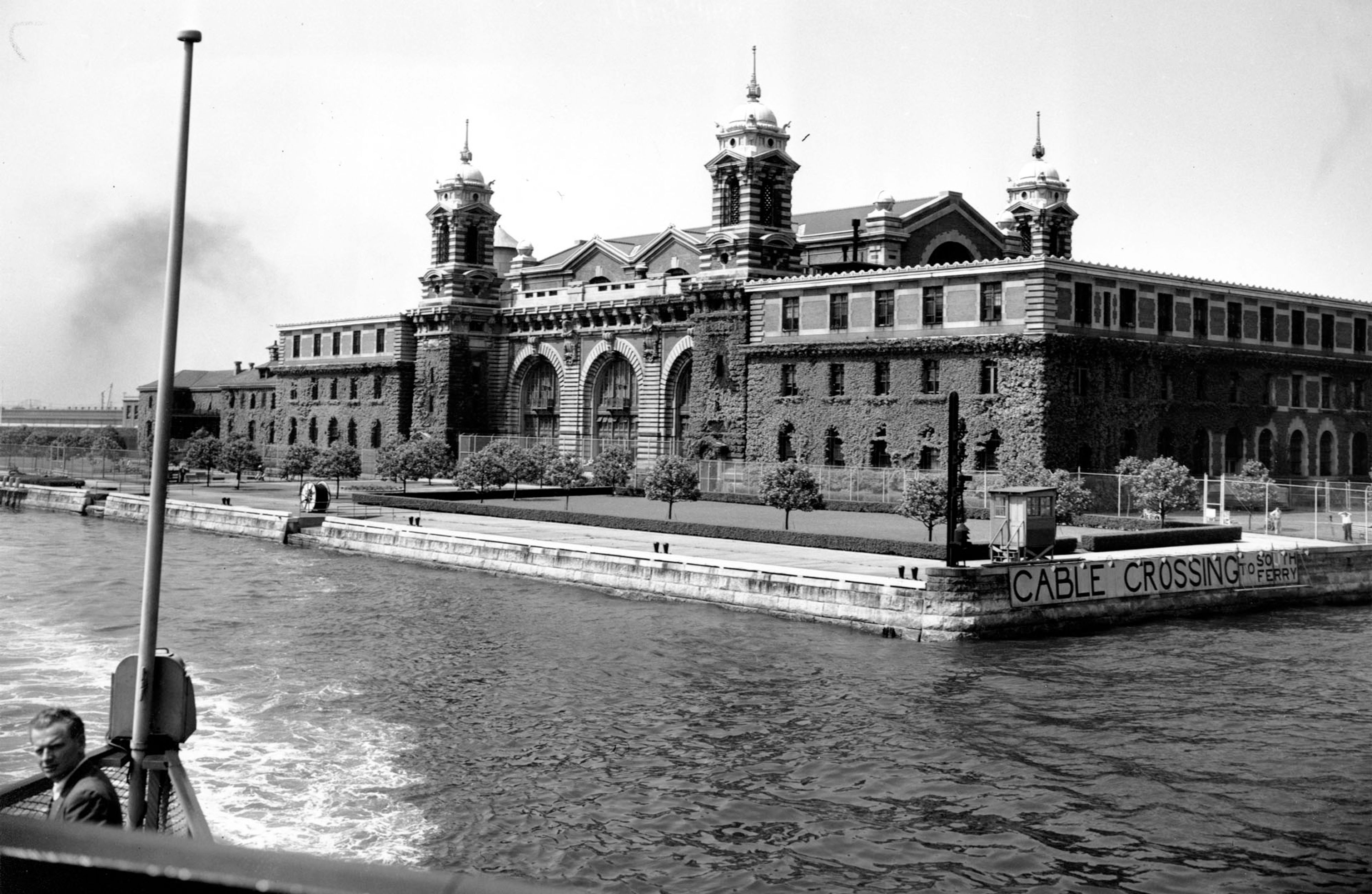 This photo shows Ellis Island Detention Station in New York Harbor as news photographers return to Manhattan after a visit to the island on June 13, 1947. The U.S. Immigration and Naturalization Service permitted photographs to be taken on the Island, but no close-ups of individuals and detainees. 