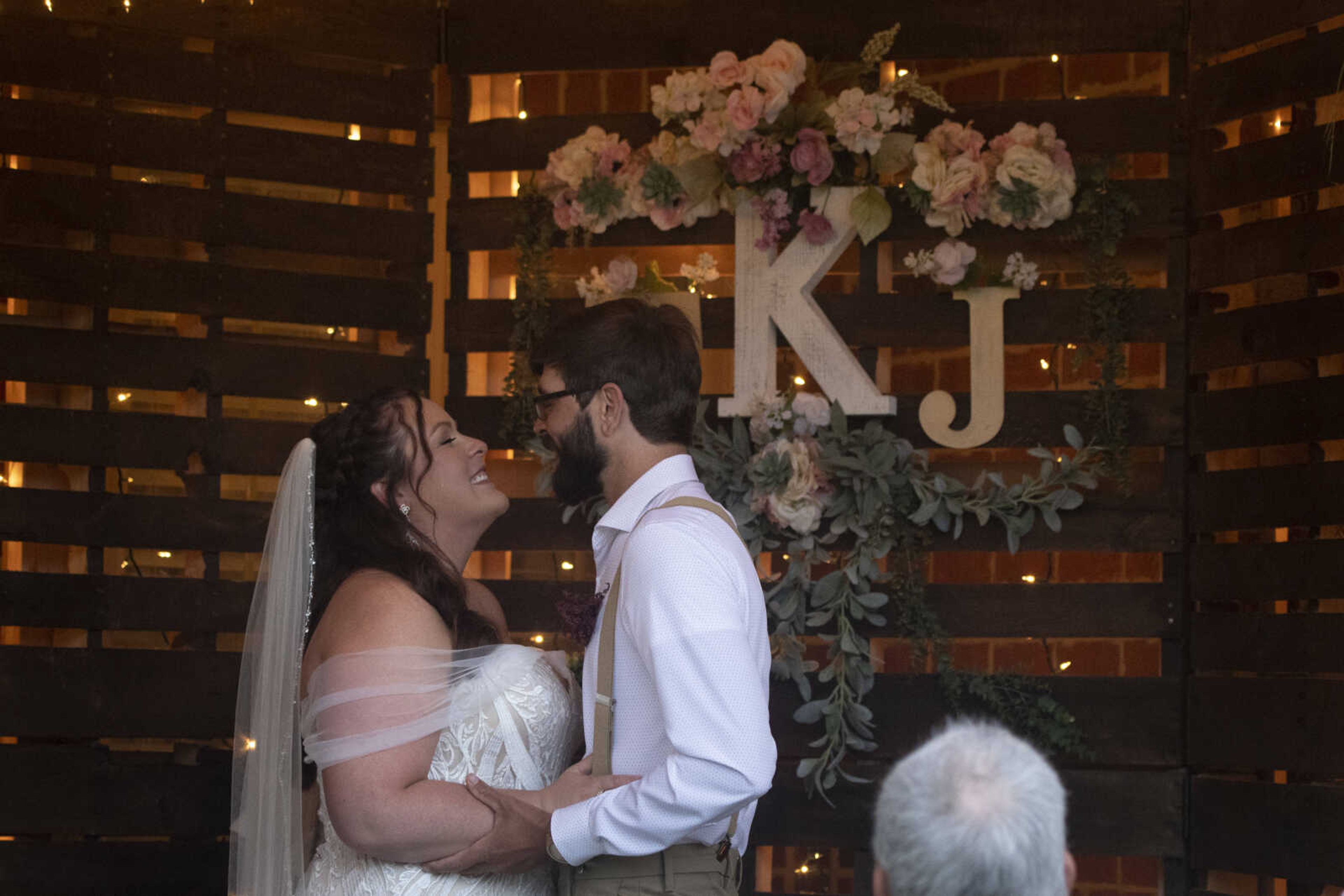 Jenni (Heisserer) Kroenung and Trevor Kroenung share a moment after kissing during their wedding ceremony Saturday, April 25, 2020, in Scott County, Missouri.