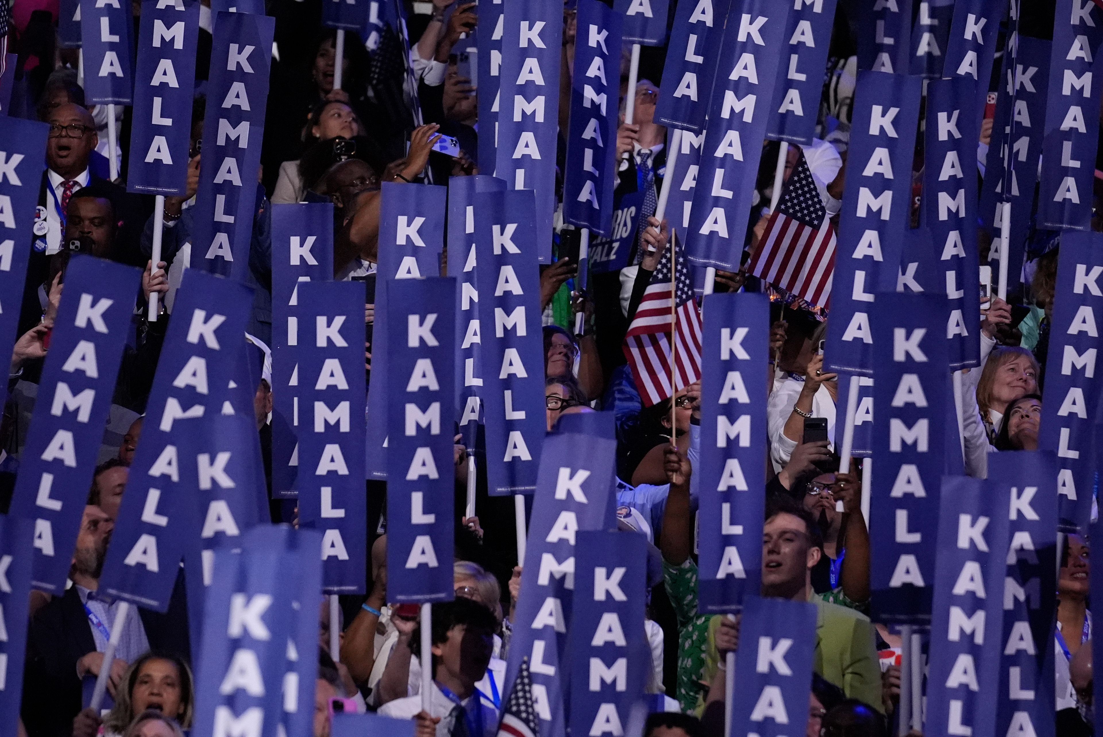 Delegates hold signs as Democratic presidential nominee Vice President Kamala Harris speaks during the Democratic National Convention Thursday, Aug. 22, 2024, in Chicago. (AP Photo/Brynn Anderson)