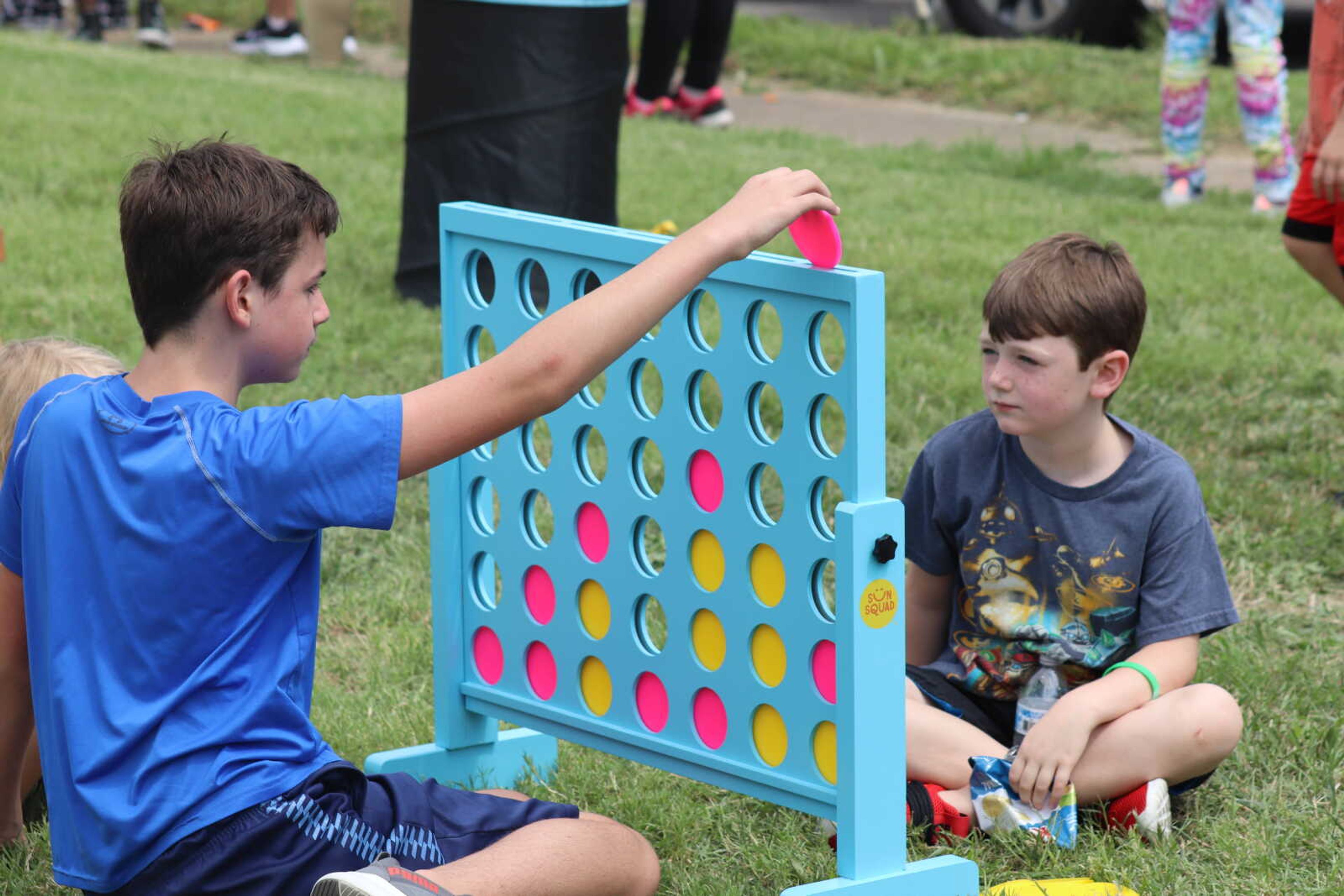 Two children play a game of Connect Four outside on Saturday.