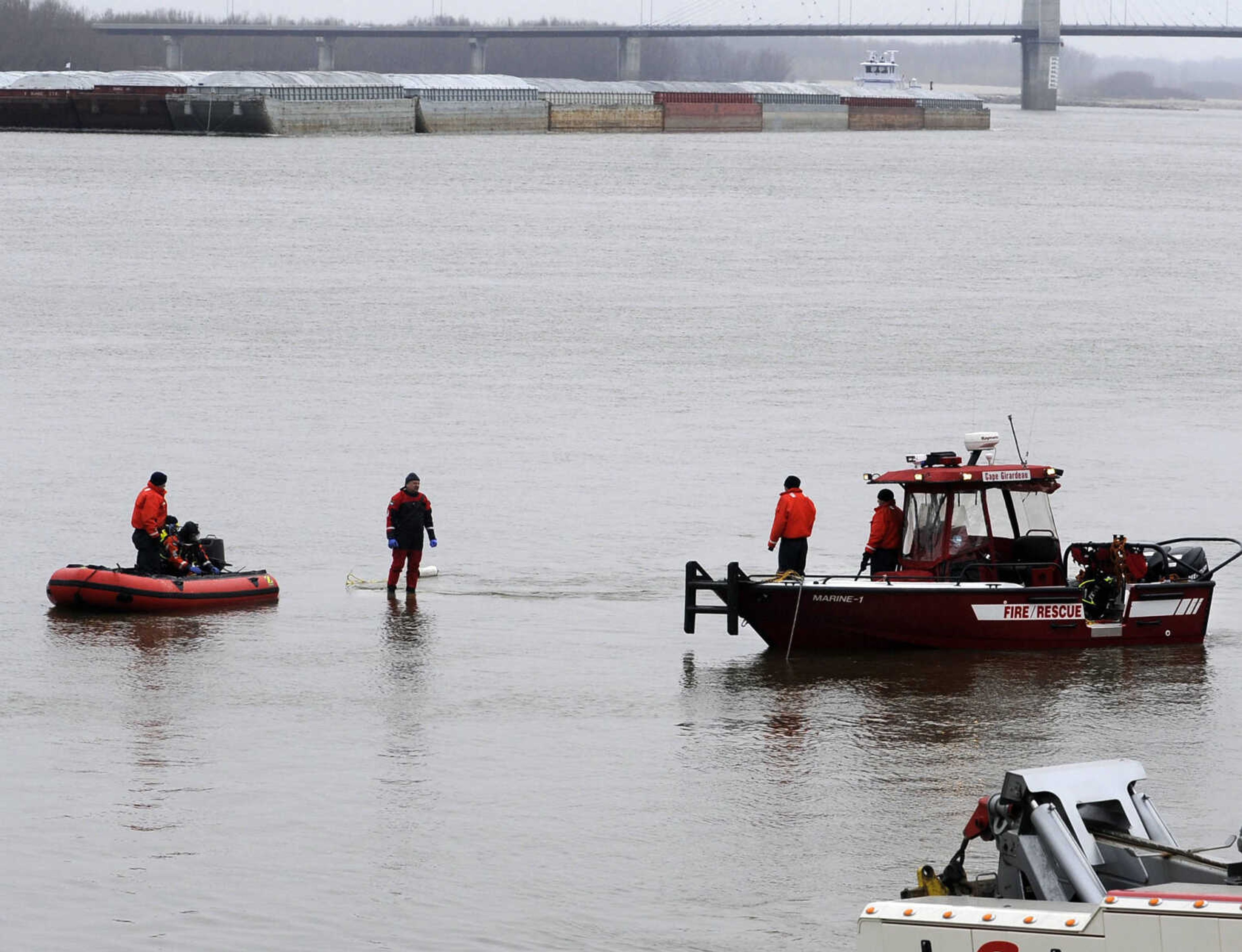 Cape Girardeau Fire/Rescue team members attach a cable to a submerged passenger car in the Mississippi River Friday, Jan. 17, 2014 just south of the Red Star boat access area. (Fred Lynch)