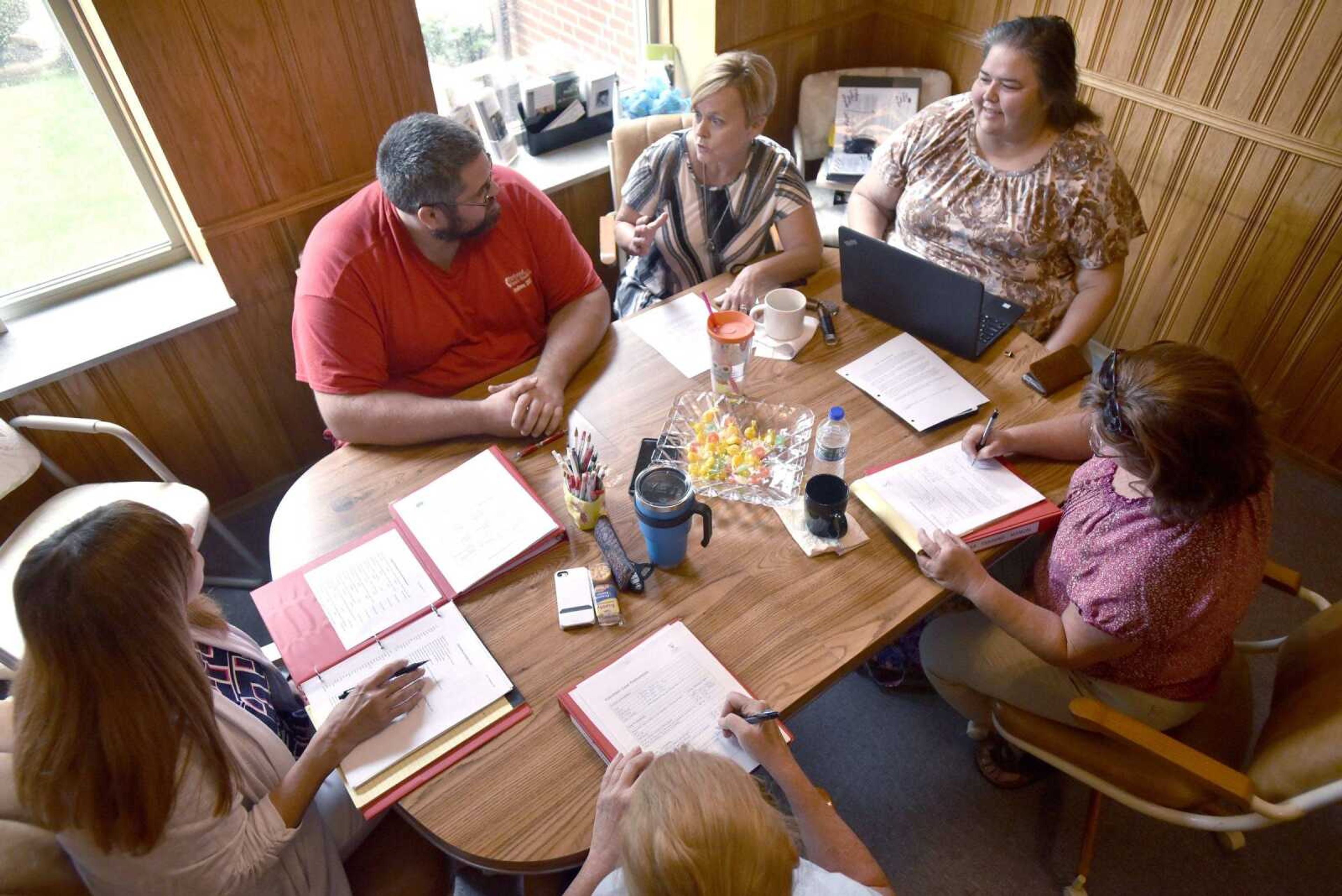 Volunteers review training materials June 26 at the Voices for Children/CASA office at 937 Broadway in Cape Girardeau.