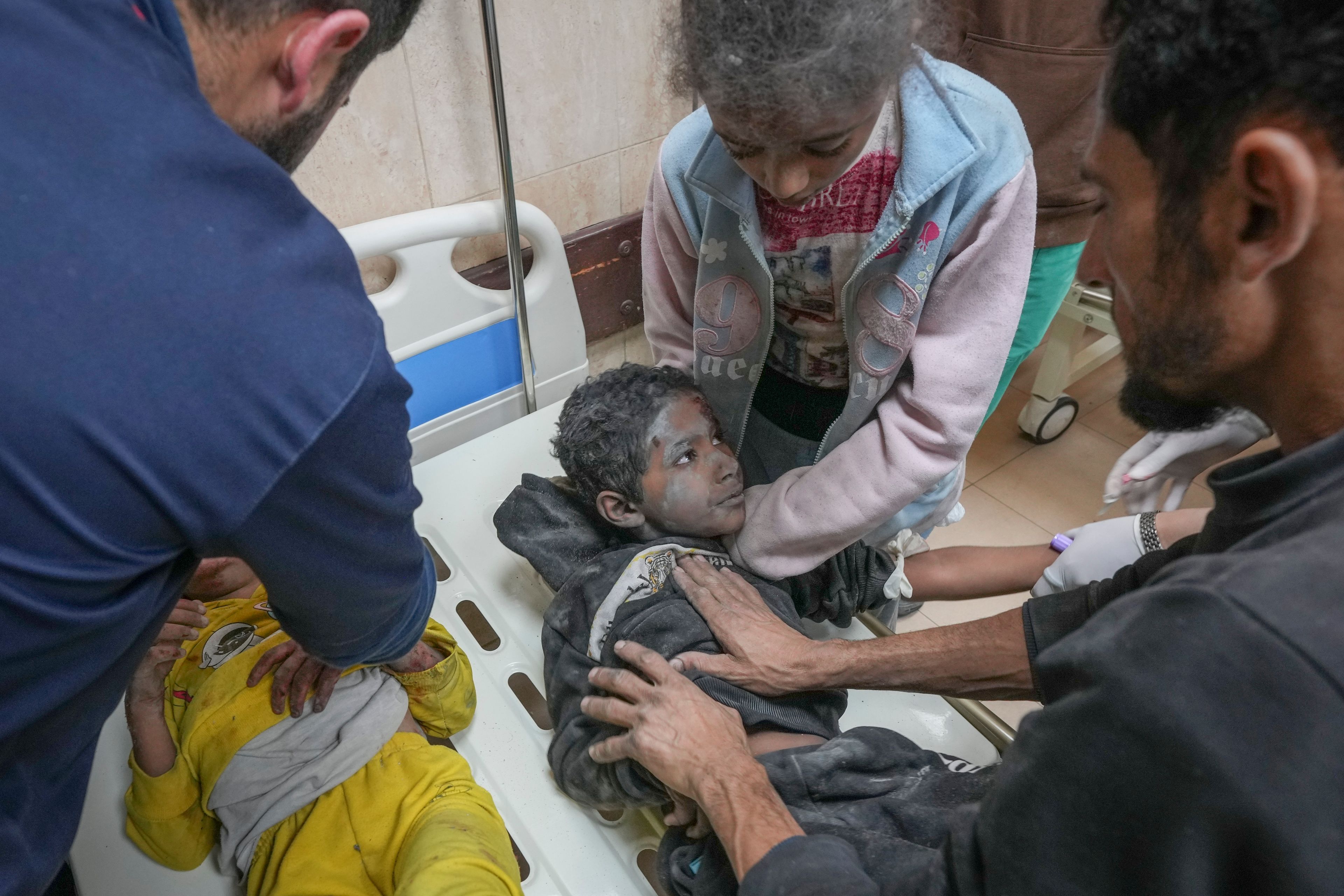 Injured children during an overnight Israeli army strike are assisted upon their arrival at the hospital in Deir al-Balah, Gaza Strip, Sunday Nov. 24, 2024. (AP Photo/Abdel Kareem Hana)