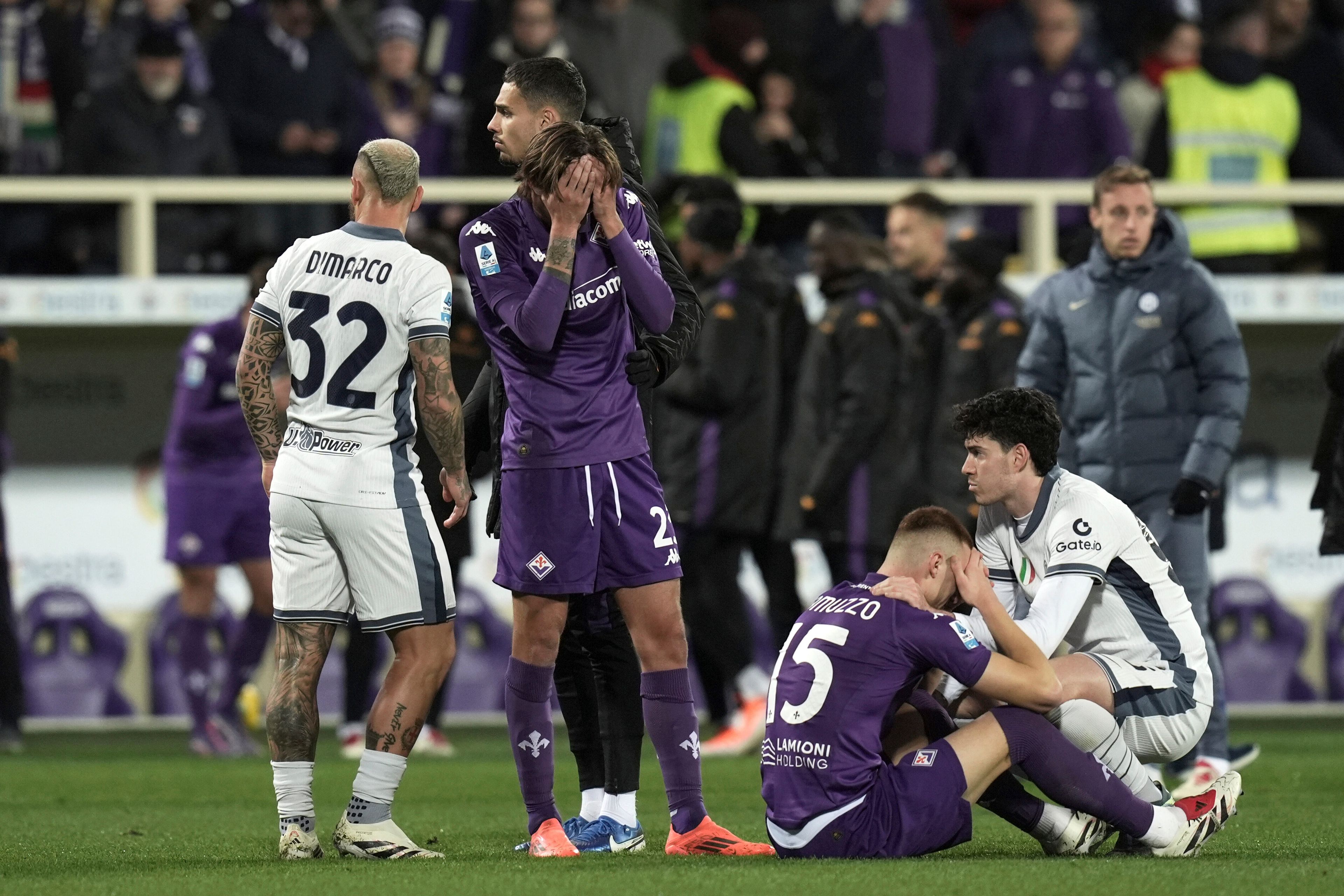 Emotional players comfort each others as Fiorentina's Edoardo Bove, injured, is taken to hospital during the Serie A soccer match between Fiorentina and Inter at the Artemio Franchi Stadium in Florence, Italy, Sunday Dec. 1, 2024. The match was suspended and finally postponed. (Massimo Paolone/LaPresse via AP)