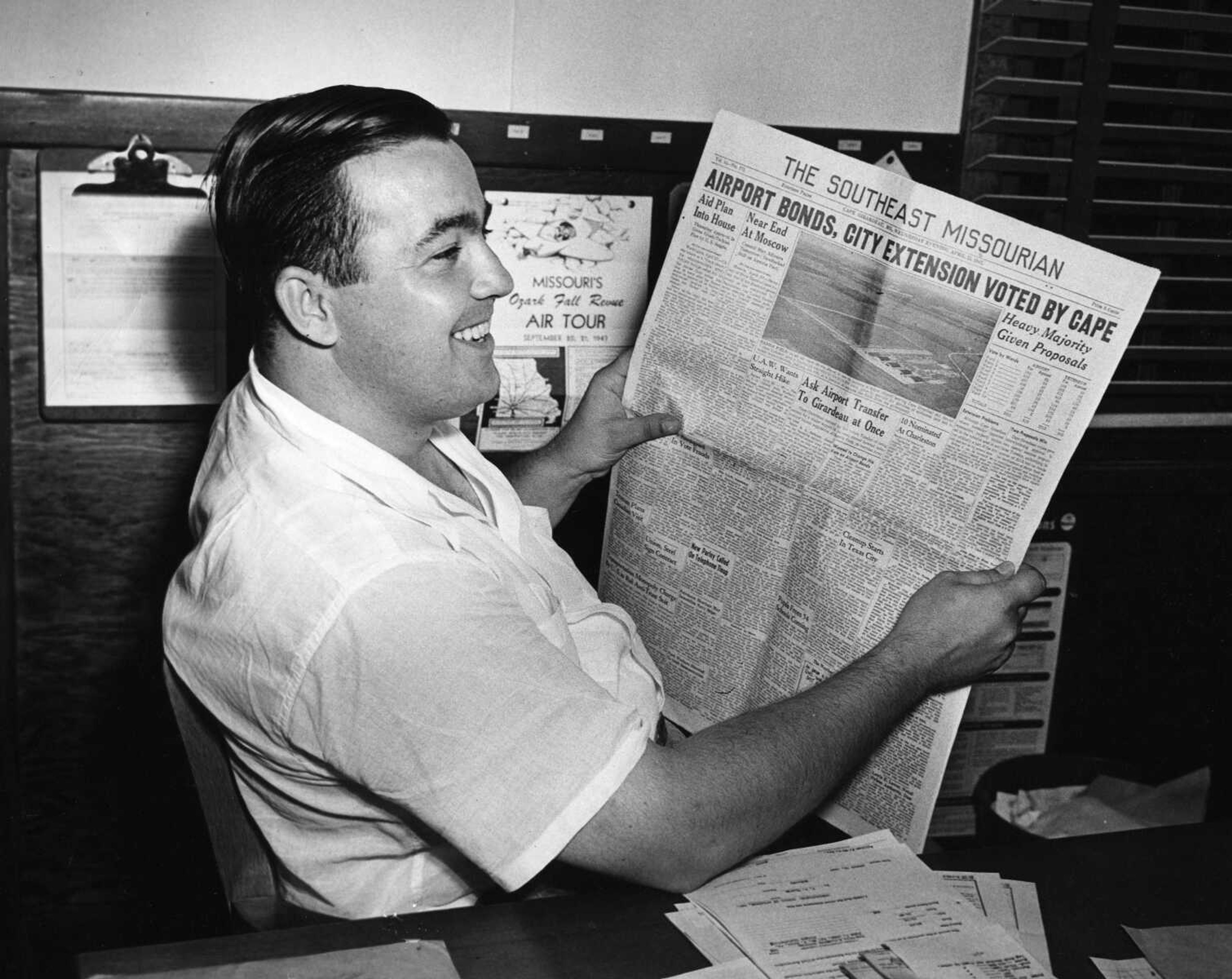 Southeast Missourian archive
Rush H. Limbaugh Jr., a Cape Girardeau aviation enthusiast, smiles as he reads a newspaper account of voter approval of the $115,000 airport bond on April 22, 1947. With the favorable vote, the city was able to move toward formal acquisition of Harris Field, a World War II flight training base.