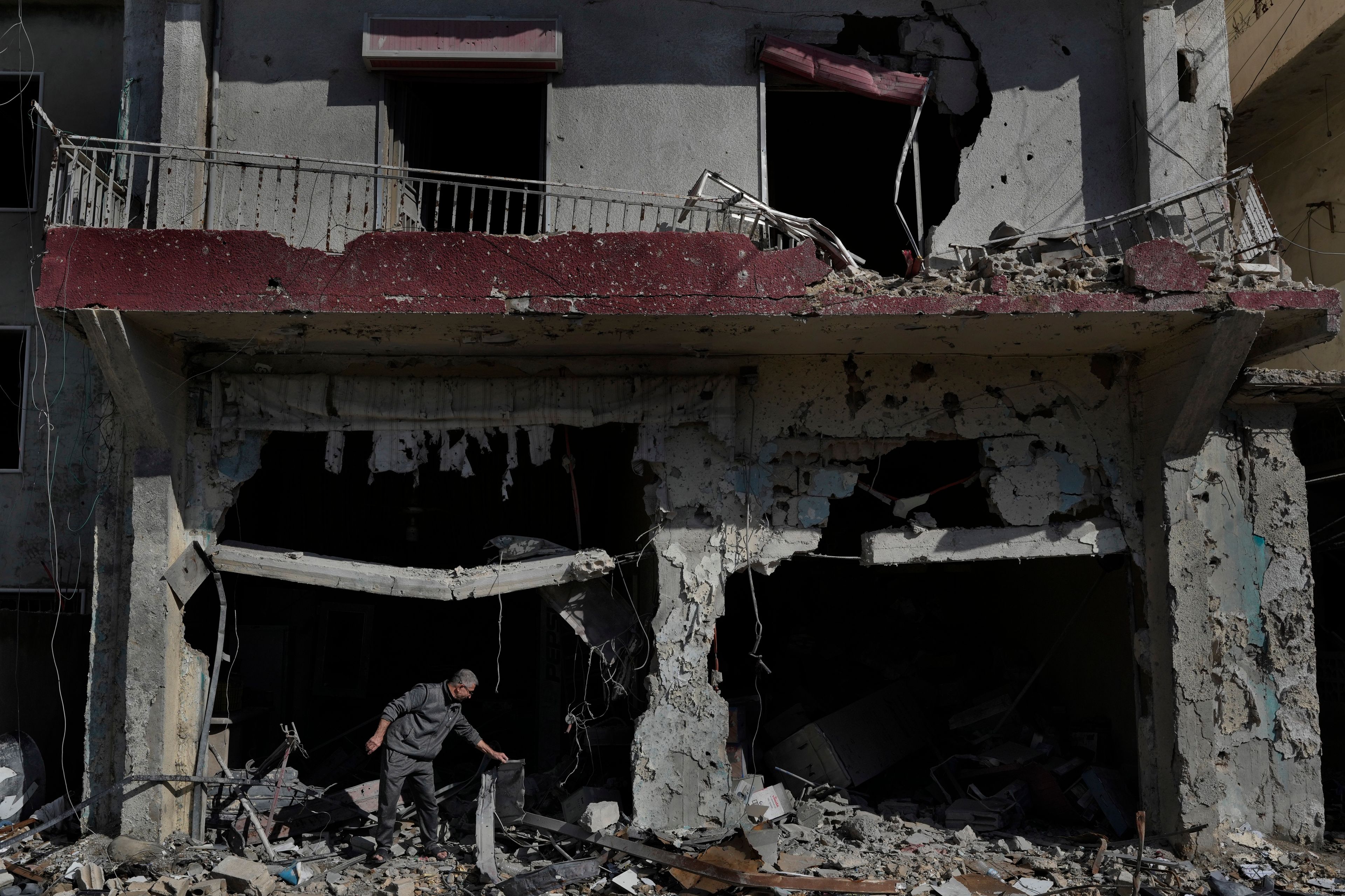 Ali Haidous, removes the debris from his destroyed butcher shop after he returned with his family to his village of Hanouiyeh, southern Lebanon, Thursday, Nov. 28, 2024 following a ceasefire between Israel and Hezbollah that went into effect on Wednesday.(AP Photo/Hussein Malla)