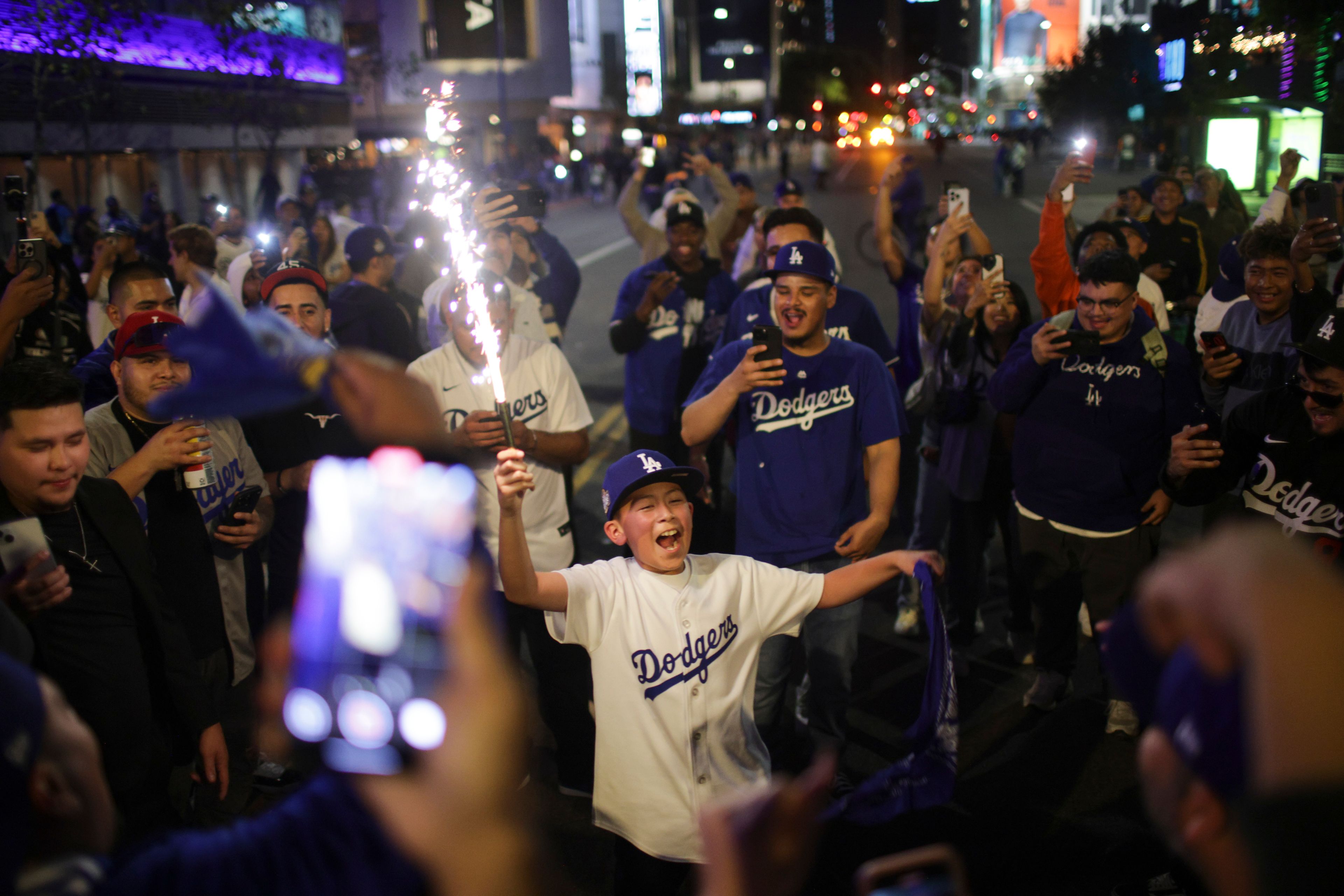 Fans celebrate on the streets after the Los Angeles Dodgers defeated the New York Yankees to win the baseball World Series Wednesday, Oct. 30, 2024, in Los Angeles. (AP Photo/Ethan Swope)