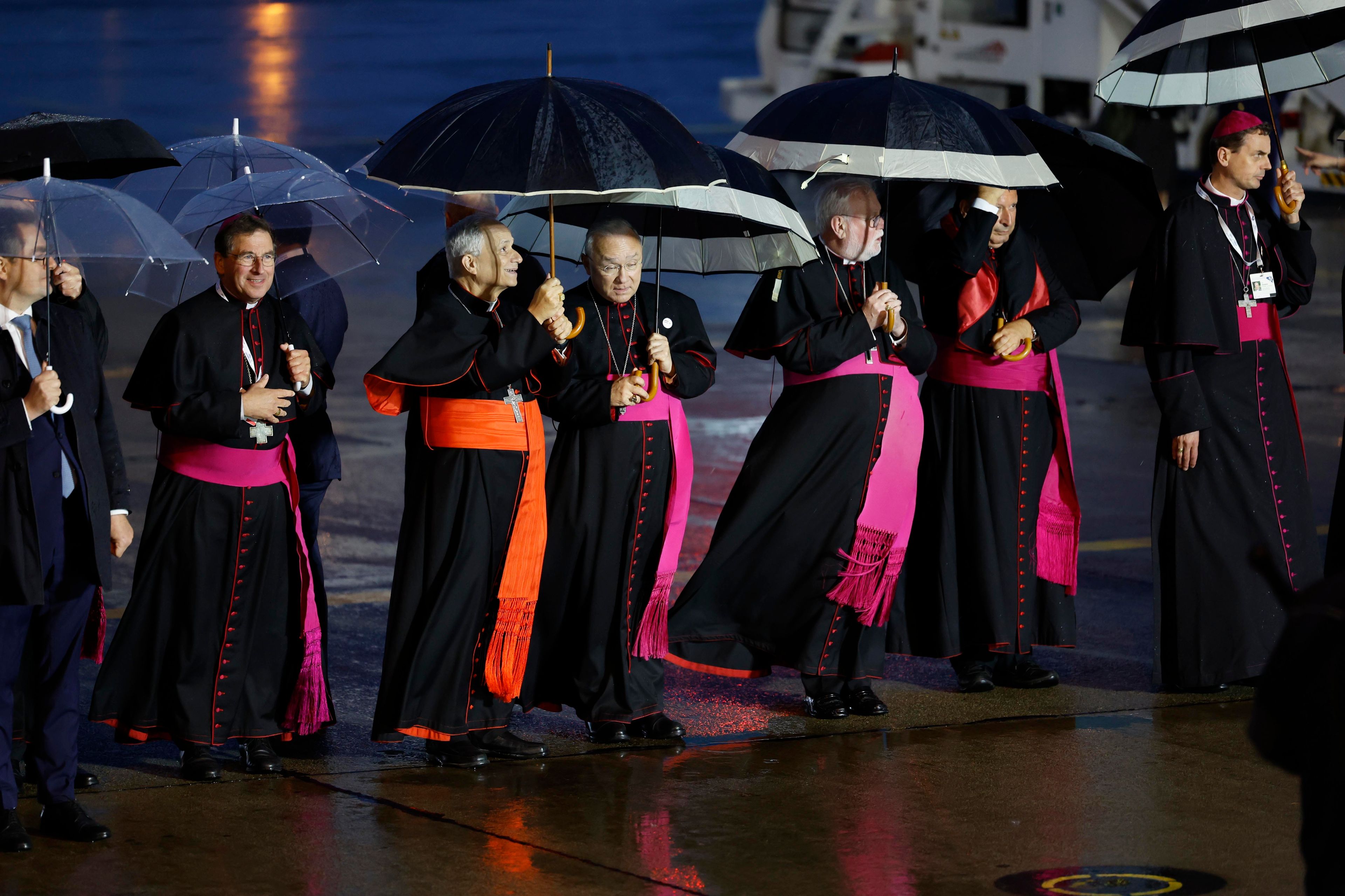 Cardinals wait for Pope Francis upon his arrival at Melsbroek air base in Steenokkerzeel, near Brussels, on the first day of his four-day visit to Luxembourg and Belgium, Thursday, Sept. 26, 2024. (AP Photo/Geert Vanden Wijngaert)