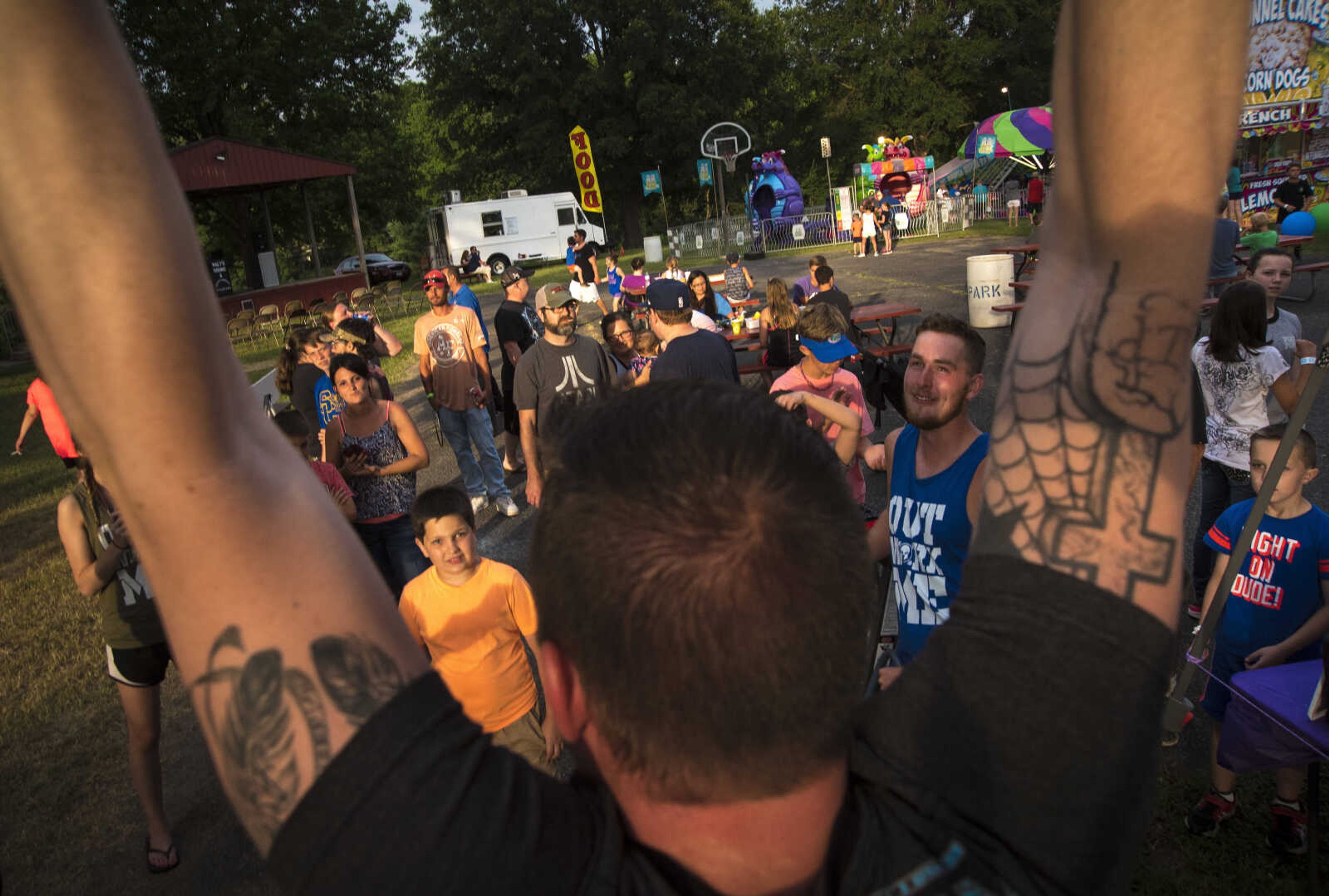 Max Brown hangs from a fitness bar from Kopion Fitness during the 41st annual Mid-Summer Festival Friday, June 16, 2017 at Scott City Park.