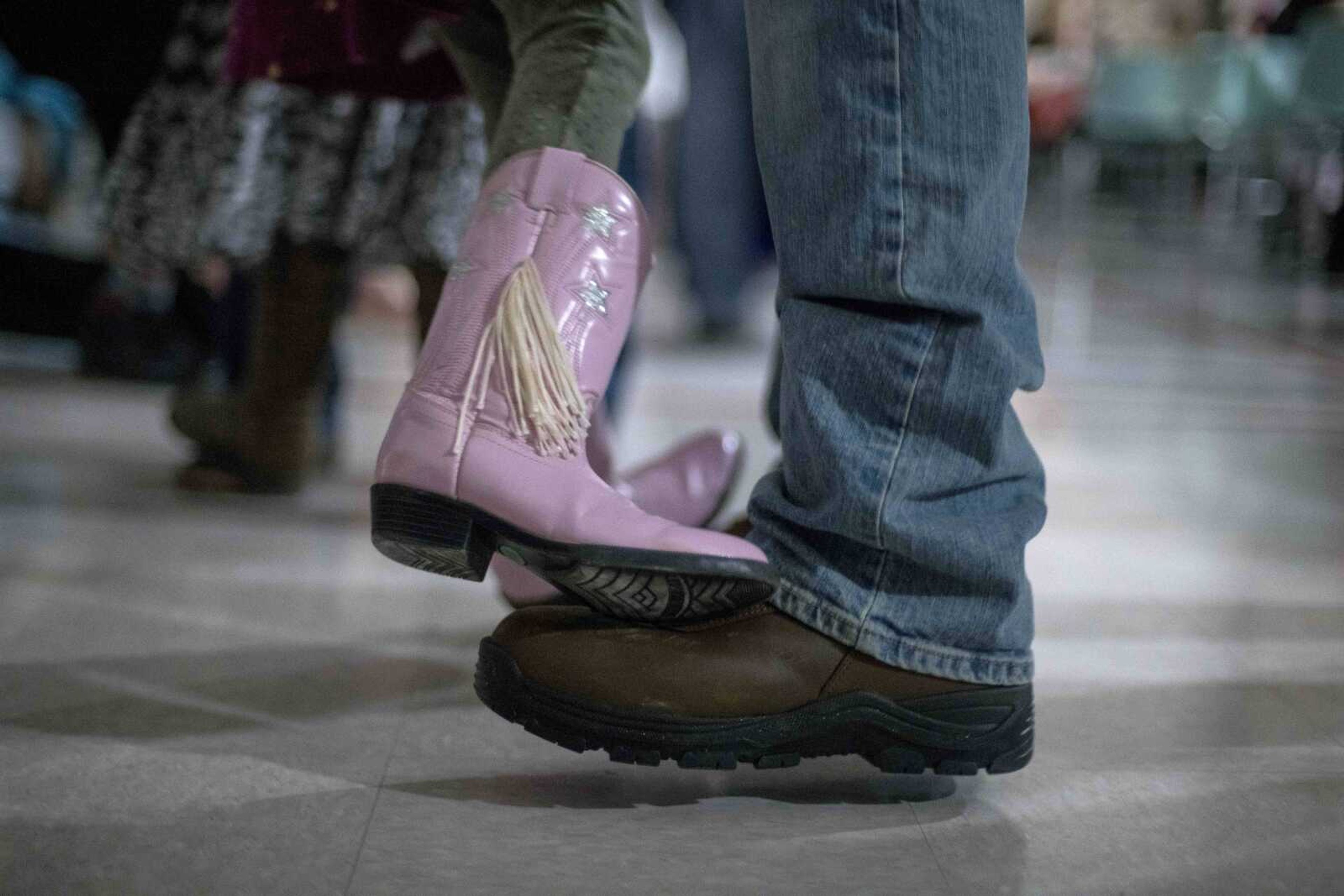 Tessa Herren, left, stands on the toes of her father, Chris, while dancing during a "Boots & Bling" themed father/daughter dance Saturday, Feb. 15, 2020, at the Osage Centre in Cape Girardeau.