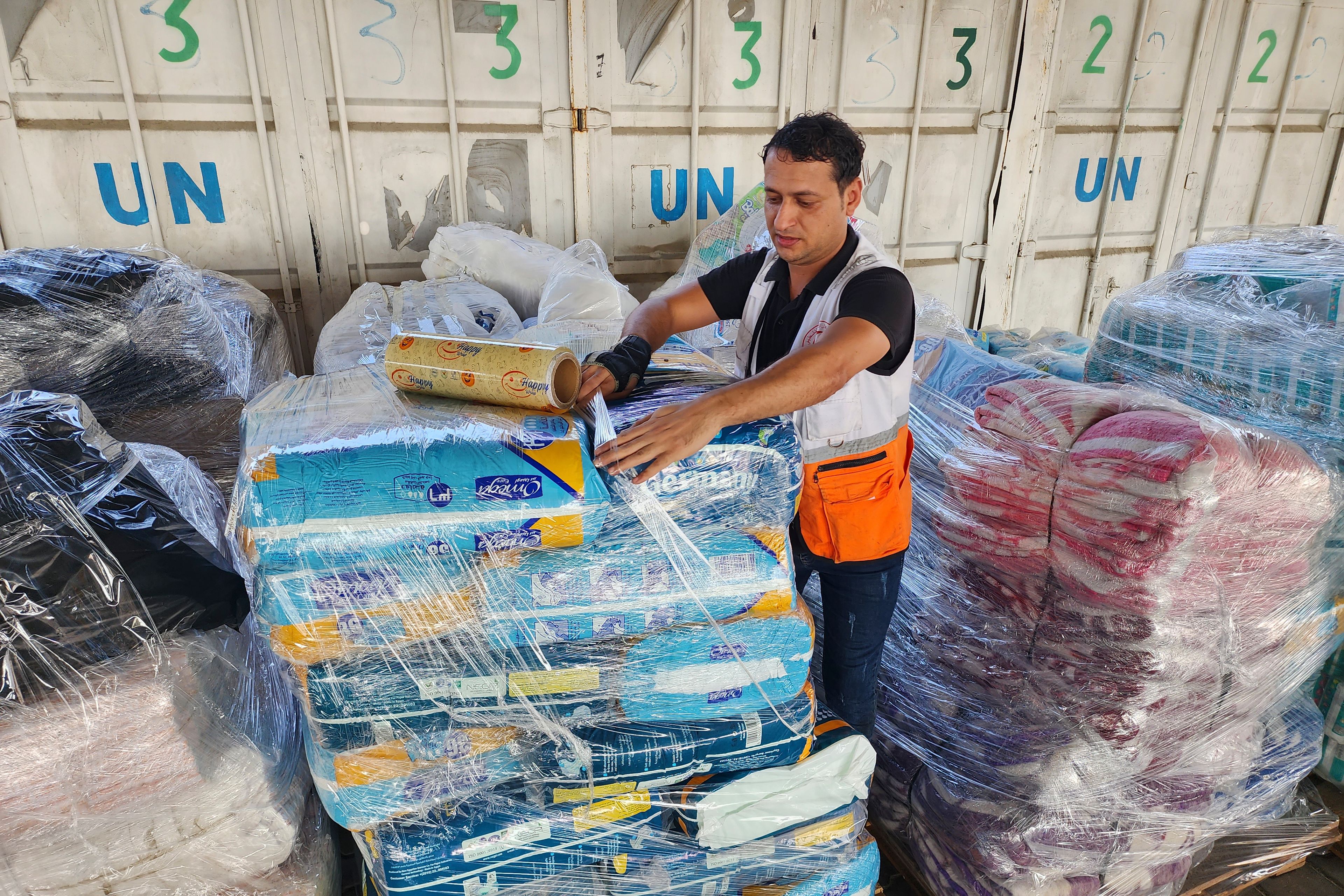 FILE - United Nations and Red Crescent workers prepare the aid for distribution to Palestinians at UNRWA warehouse in Deir Al-Balah, Gaza Strip, on Monday, Oct. 23, 2023. (AP Photo/Hassan Eslaiah, File)