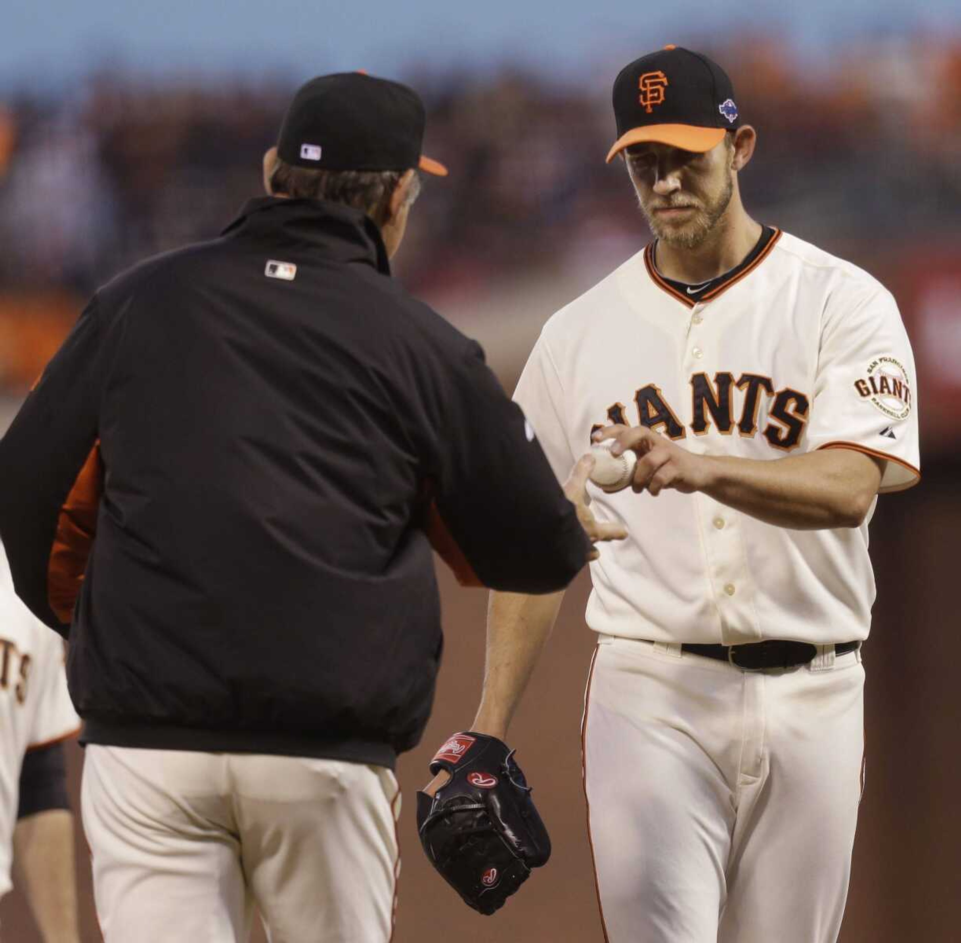 Giants starting pitcher Madison Bumgarner hands the ball to manager Bruce Bochy after being taken out of the game during the fourth inning. (Ben Margot ~ Associated Press)