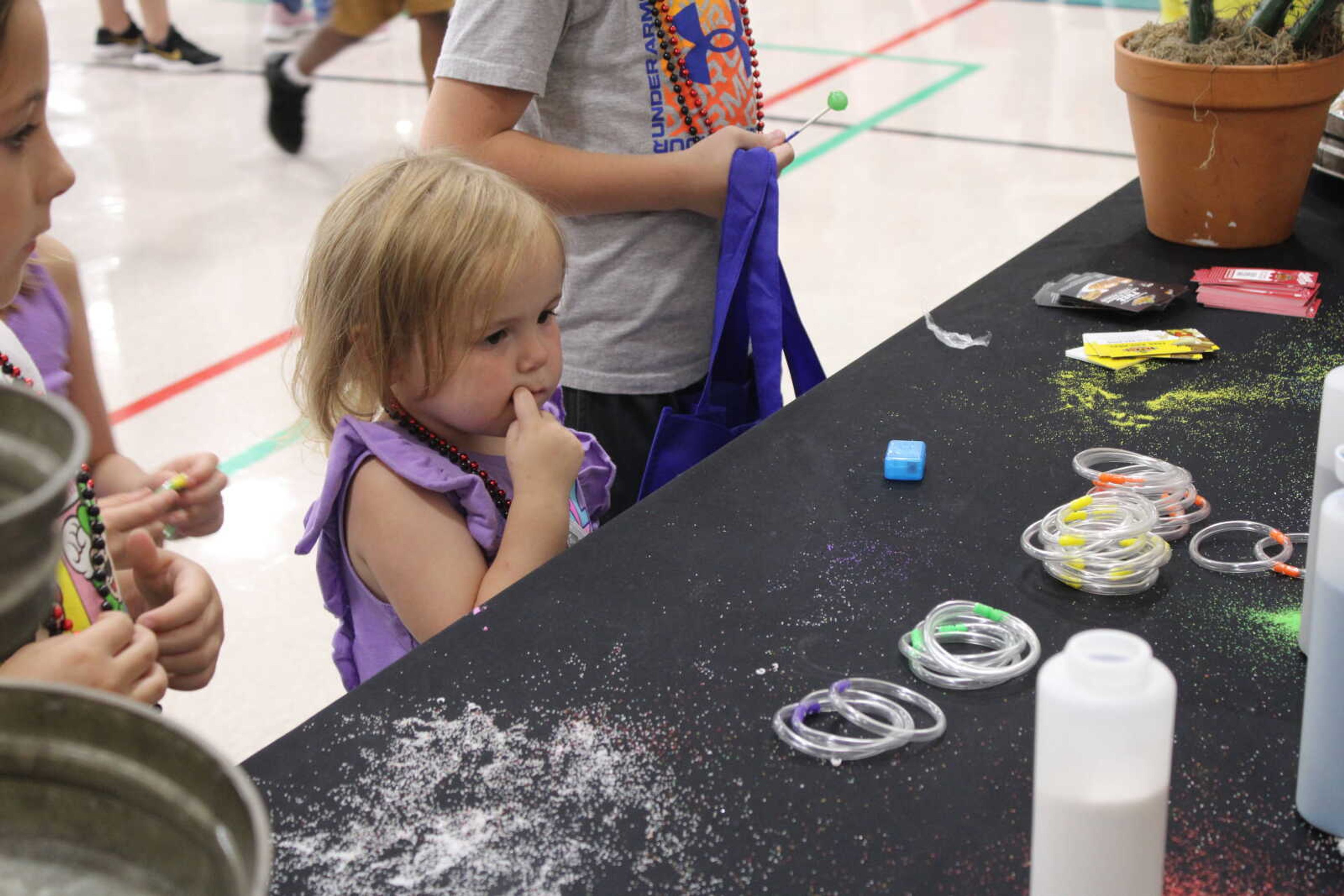 A young girl waits for her bracelet to be made by Texas Roadhouse volunteers.