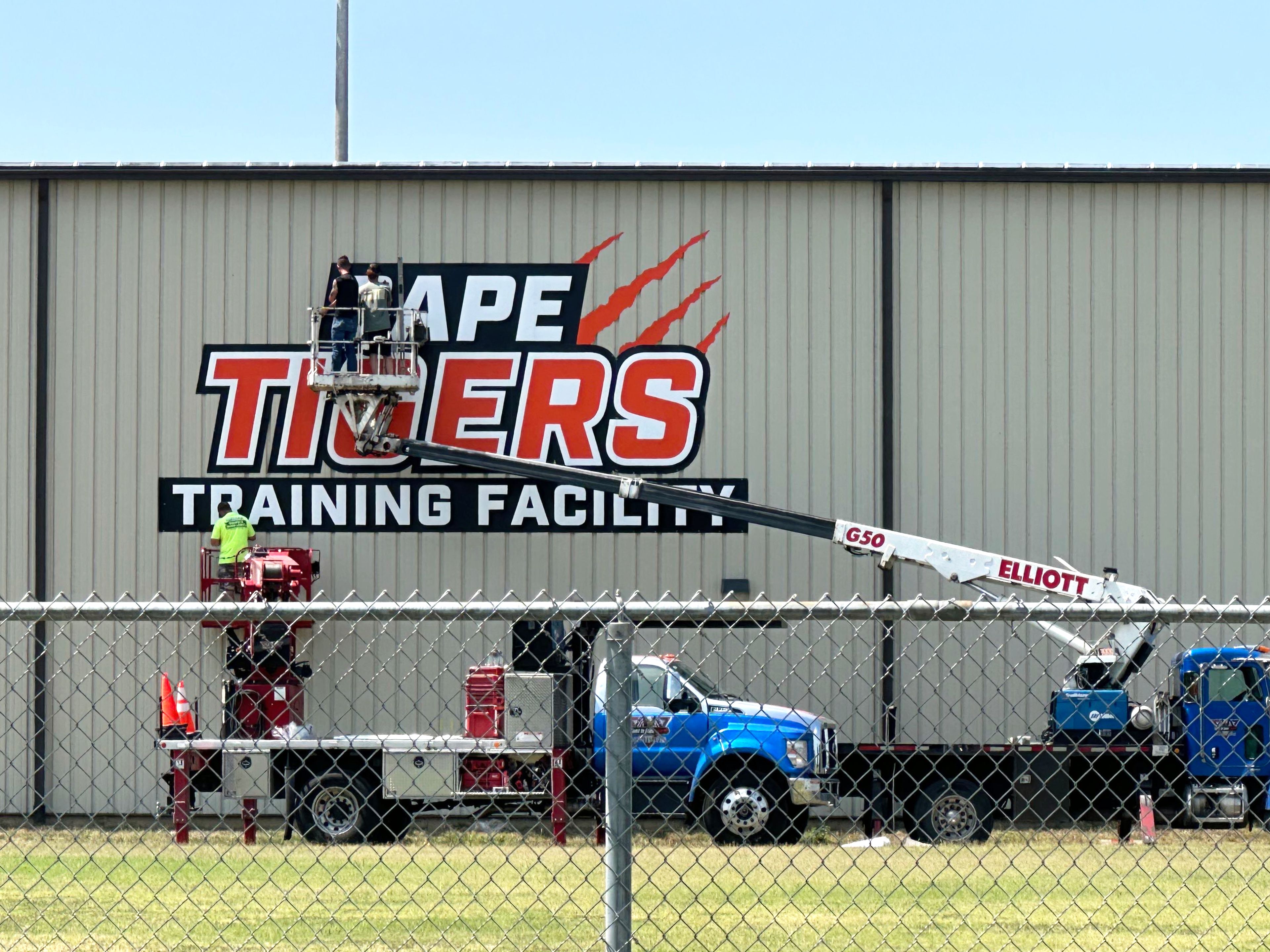 Workers finish hanging the sign on the outside of Cape Girardeau Public Schools’ new indoor athletic facility. 