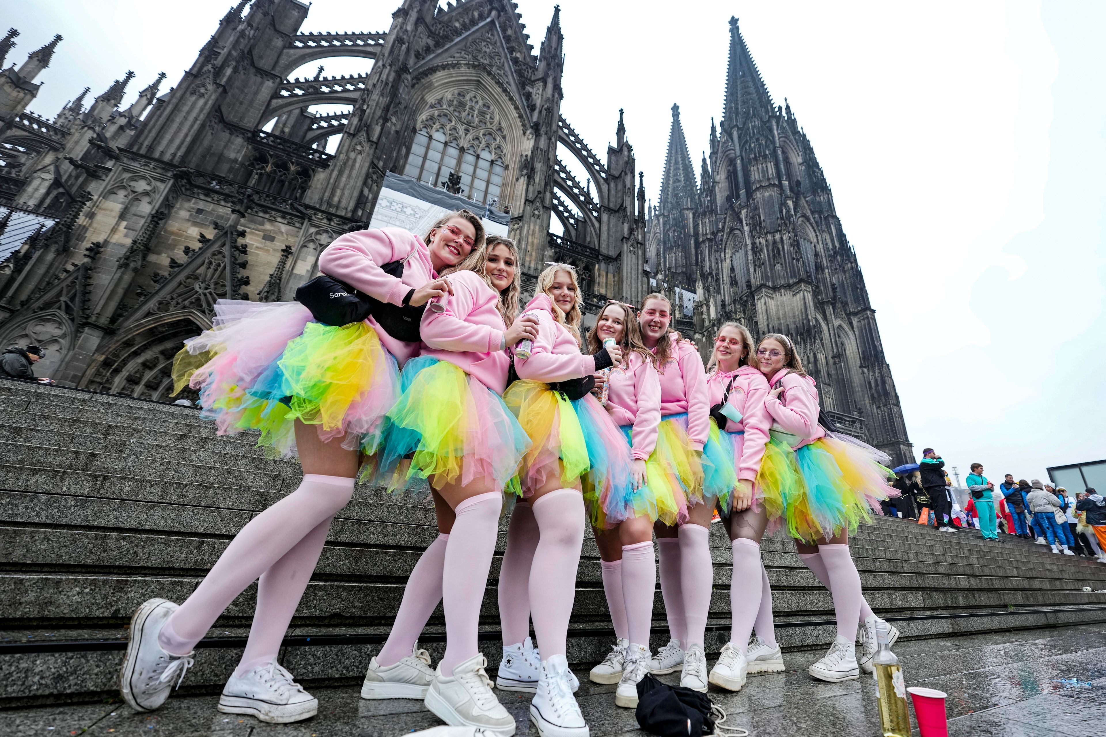 Costumed revelers pose in front of there Cologne Cathedral while tens of thousands of carnival fools take to the streets of Cologne, Germany, on Monday, November 11, 2024, heralding the official start of the carnival season. (AP Photo/Martin Meissner)