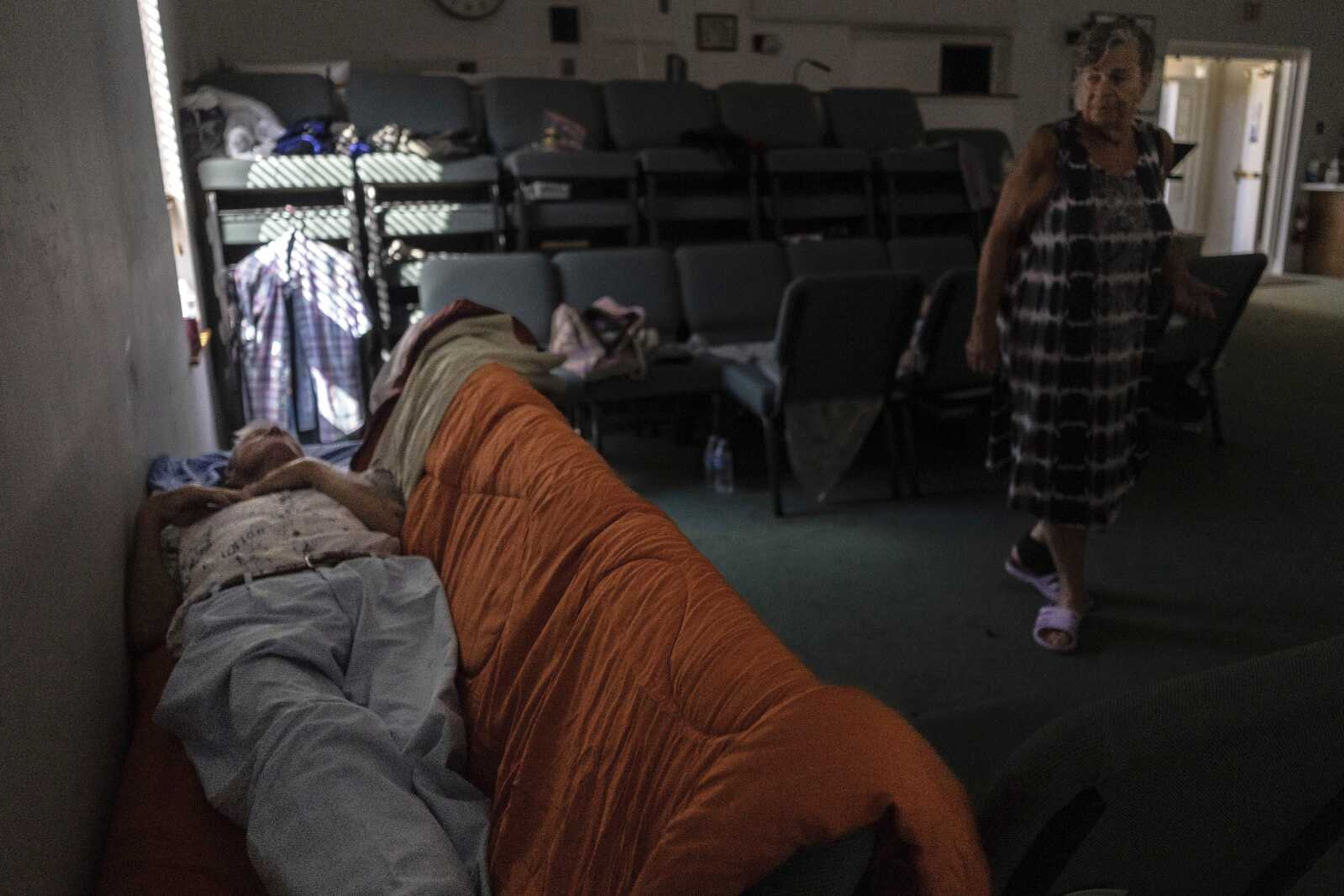 A man sleeps inside the sanctuary of Southwest Baptist Church on Sunday in Fort Myers, Florida. The church has become a shelter for more than a dozen parishioners after Hurricane Ian devastated the region.