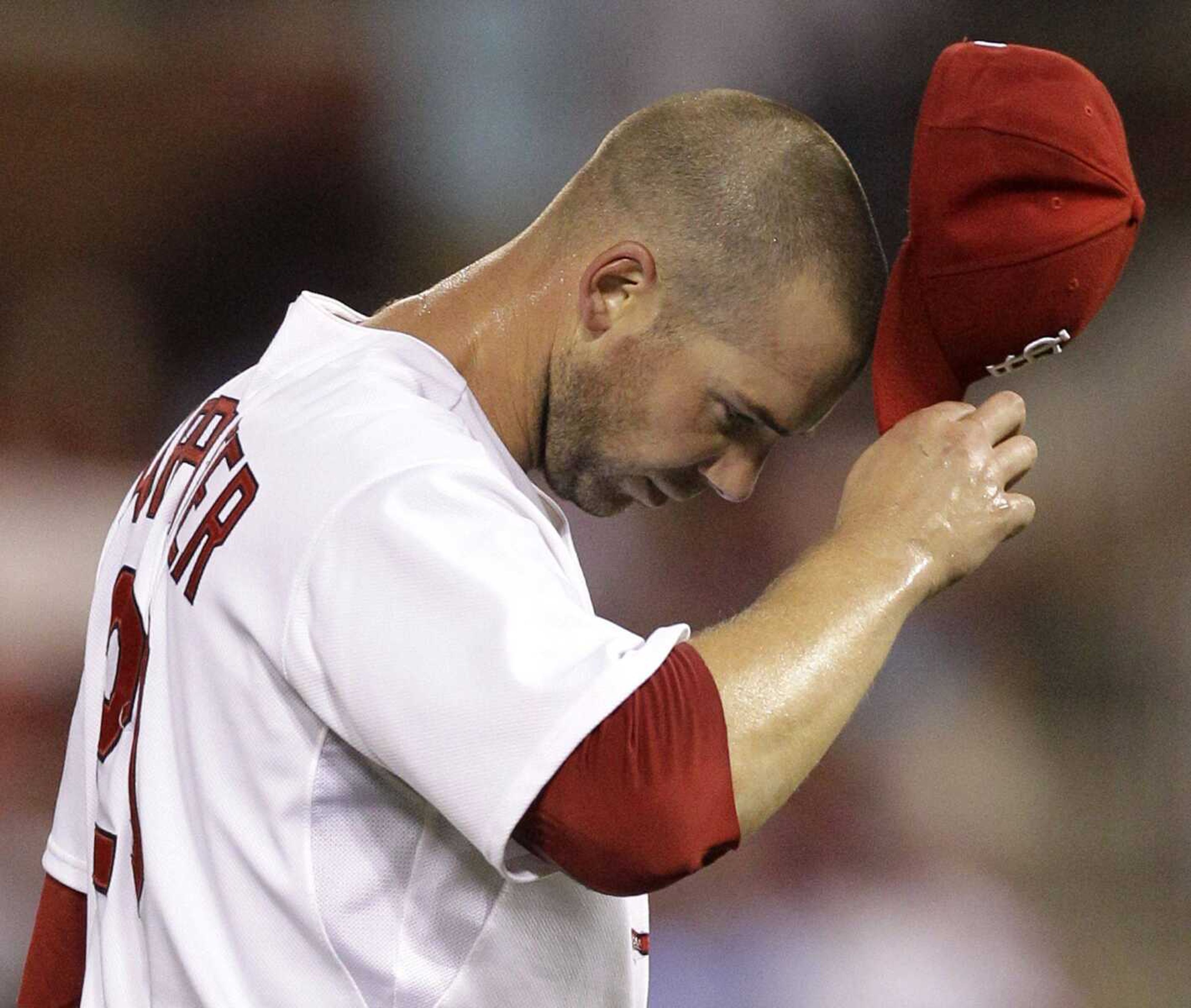 Cardinals starting pitcher Chris Carpenter adjusts his cap while working against the Cubs during the first inning of Wednesday's game in St. Louis. (JEFF ROBERSON ~ Associated Press)