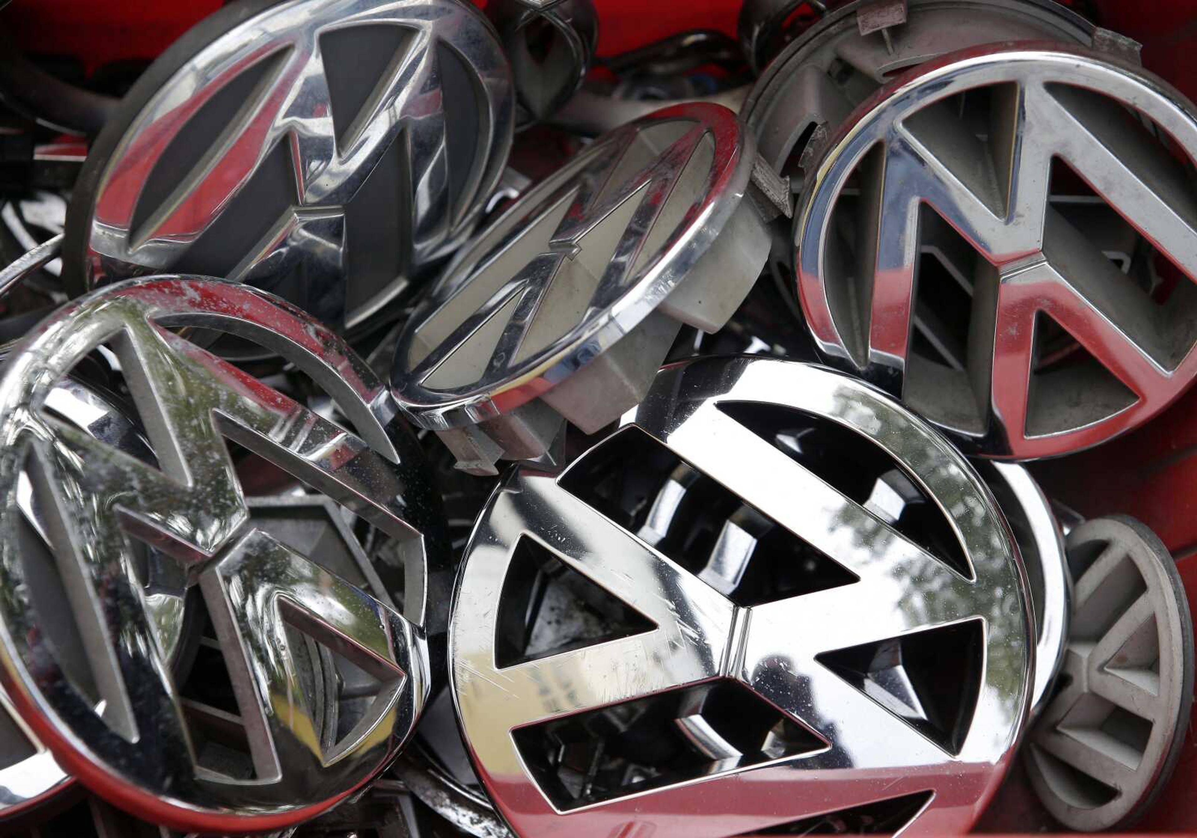 Volkswagen ornaments sit in a box in a scrap yard in Berlin, Germany. (Michael Sohn ~ Associated Press)