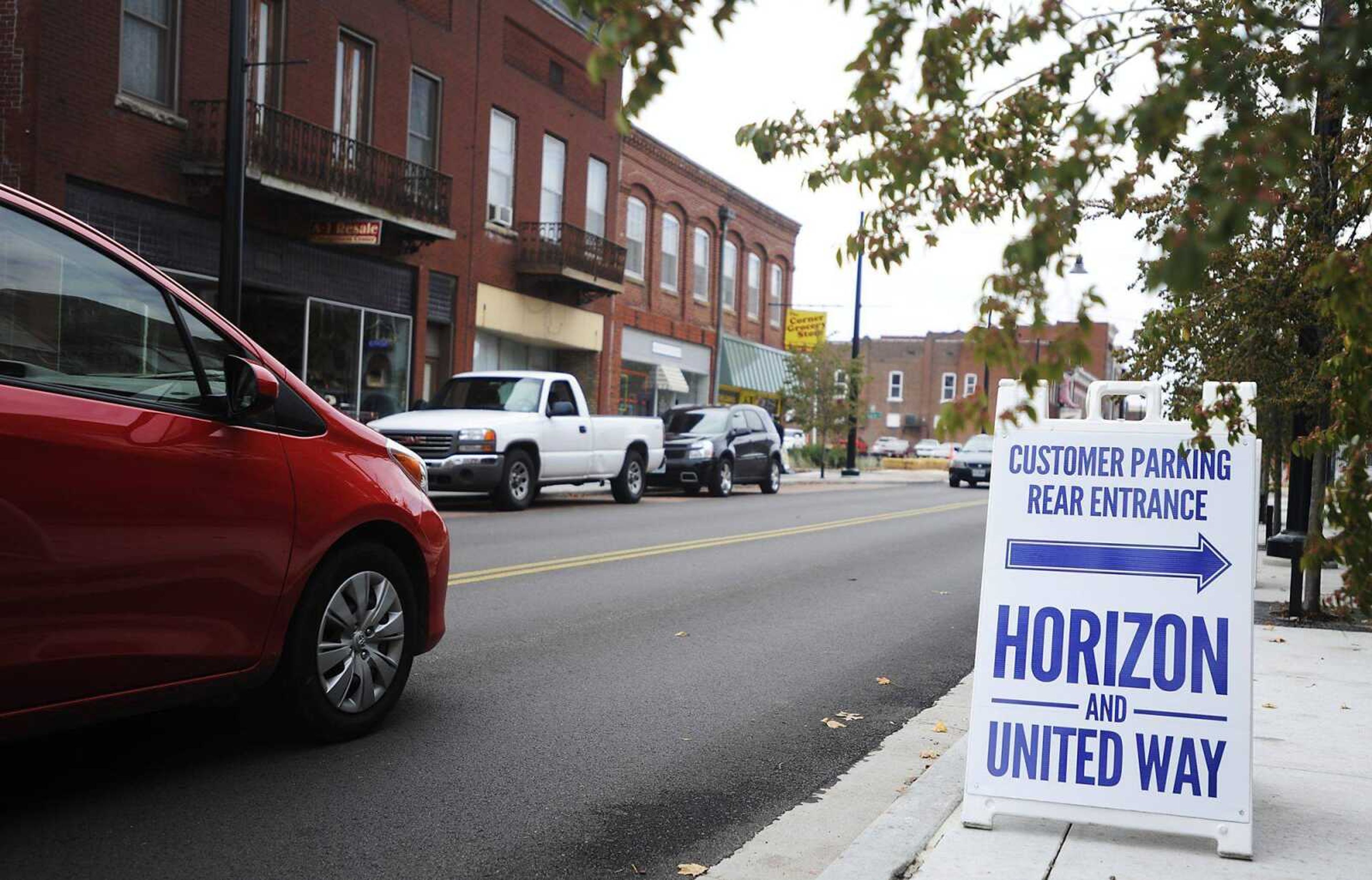 A sign points toward available parking Friday for the United Way and Horizon Screen Printing, 430 Broadway. The street project eliminated parking on the north side, causing some offices to emphasize off-street parking. (ADAM VOGLER)