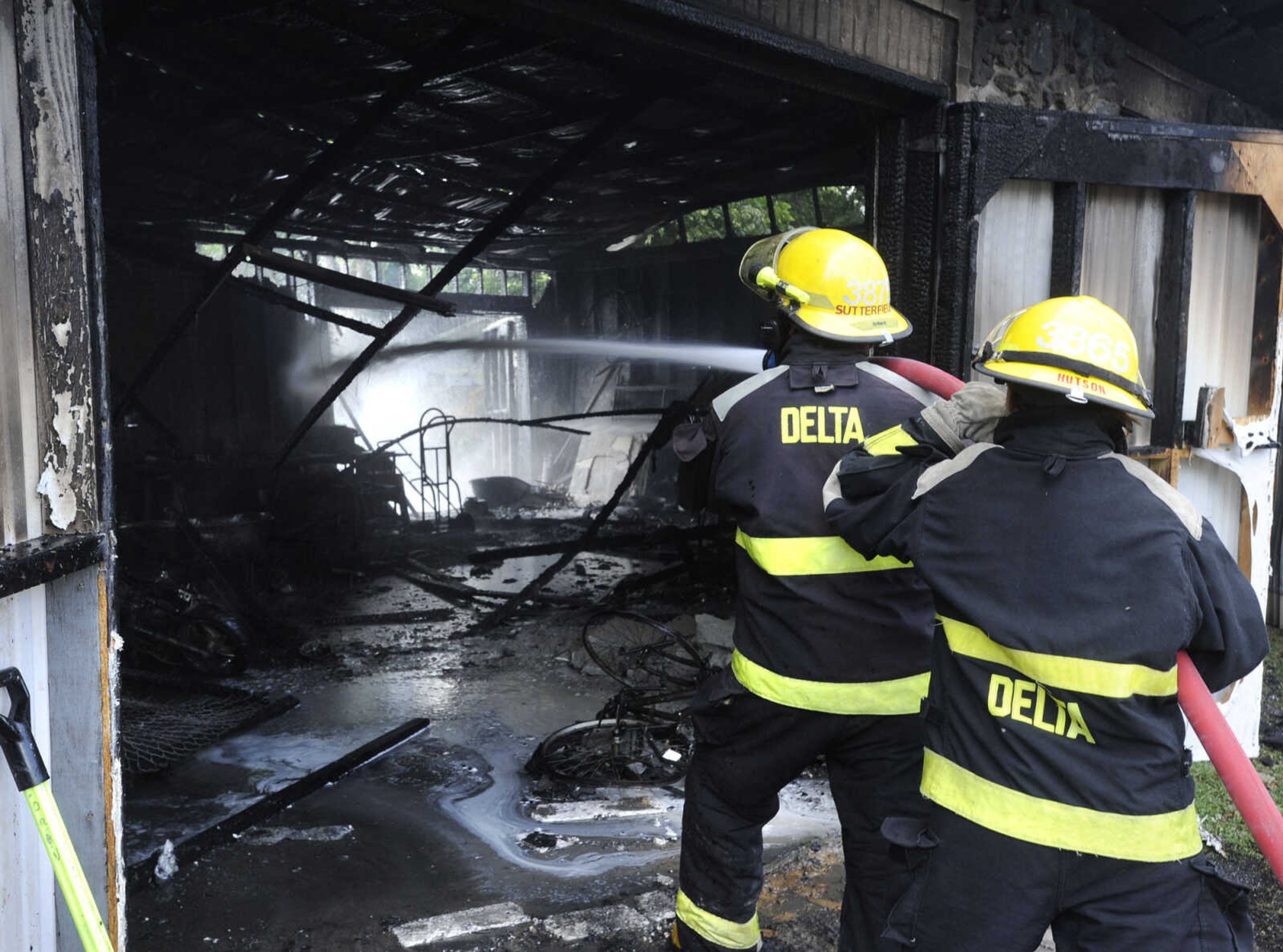 Delta firefighters hose down hot spots inside a shed that fire destroyed Monday, July 28, 2014 in Chaffee, Missouri. (Fred Lynch)