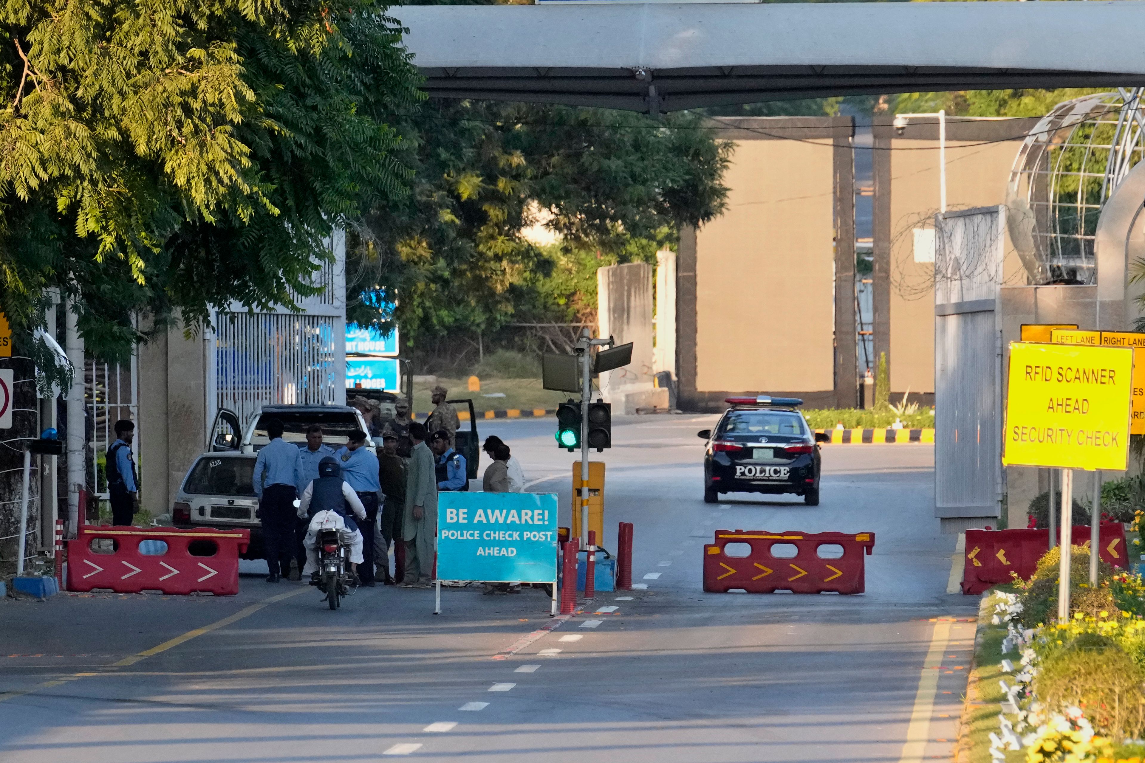 Police officer frisk a car at a checkpoint close to the venue of the upcoming Shanghai Cooperation Organization (SCO) summit in Islamabad, Pakistan, Sunday, Oct. 13, 2024. (AP Photo/Anjum Naveed)