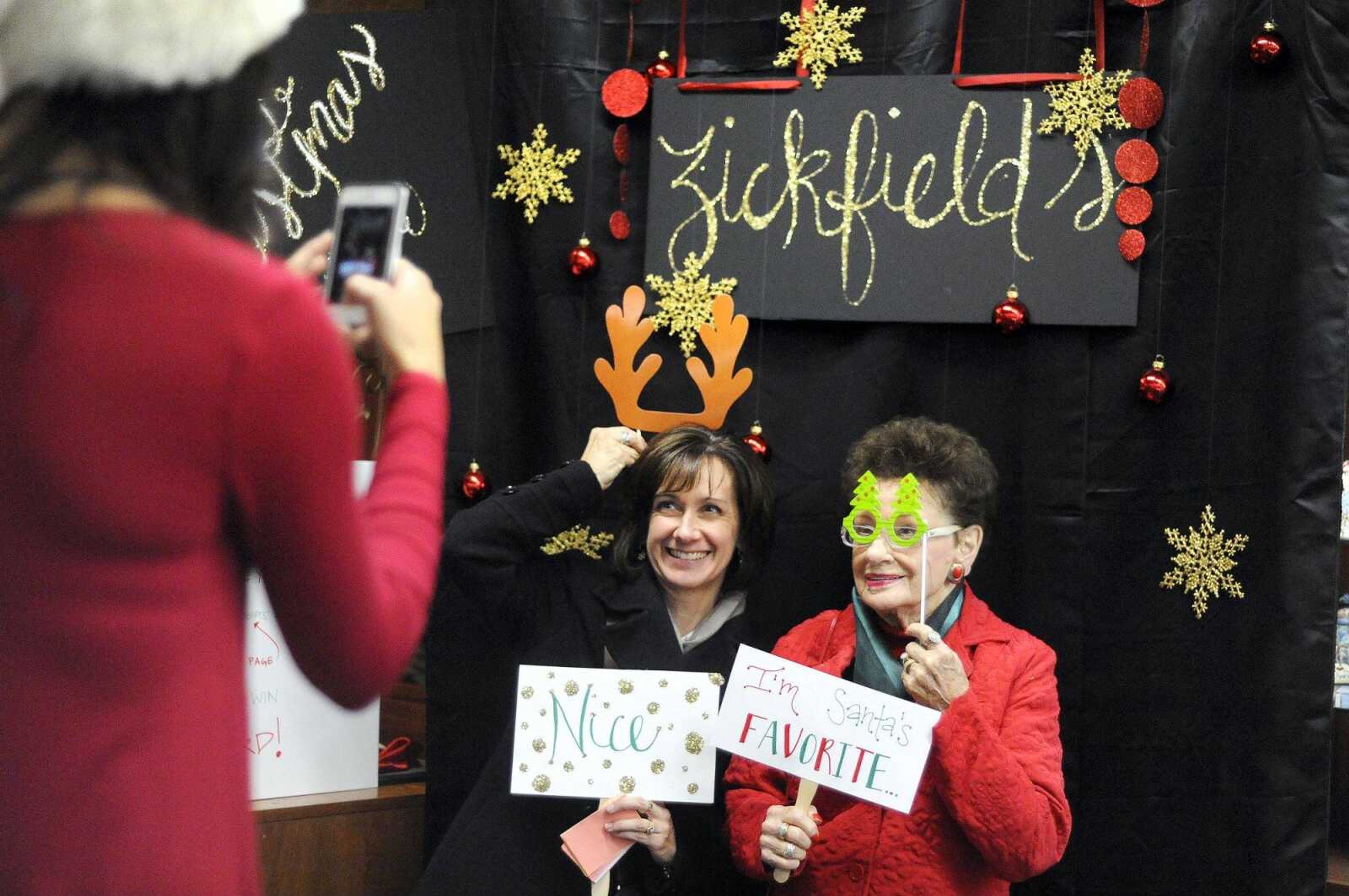 Wendi Zickfield takes a photo of Gayle Conrad, left, and Marilyn Rellergert on Dec. 4 during Old Town Cape's annual Downtown Christmas Open House in Cape Girardeau.