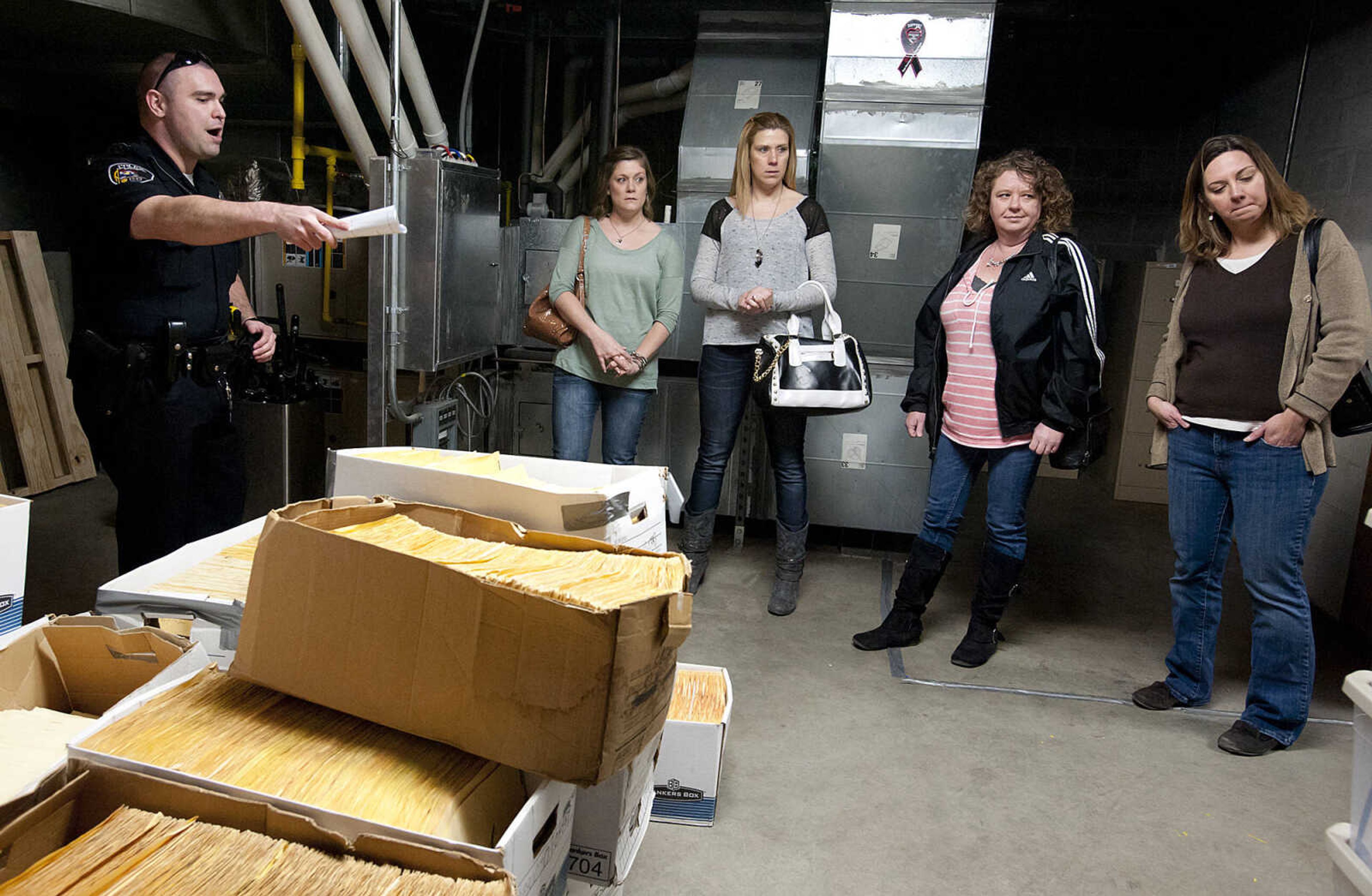 Officer Jason McDonald shows where files are stored in the basement to Christie Oswald, right, Donna Rubach, Cyndi Laster and Kim Klaus during a tour of the Cape Girardeau Police Department Friday, March 14, in Cape Girardeau. The tour was part of an open house held by the police department to show the public the problems with the current headquarters building. The building is plagued by leaks and a lack of space for personnel and storage.