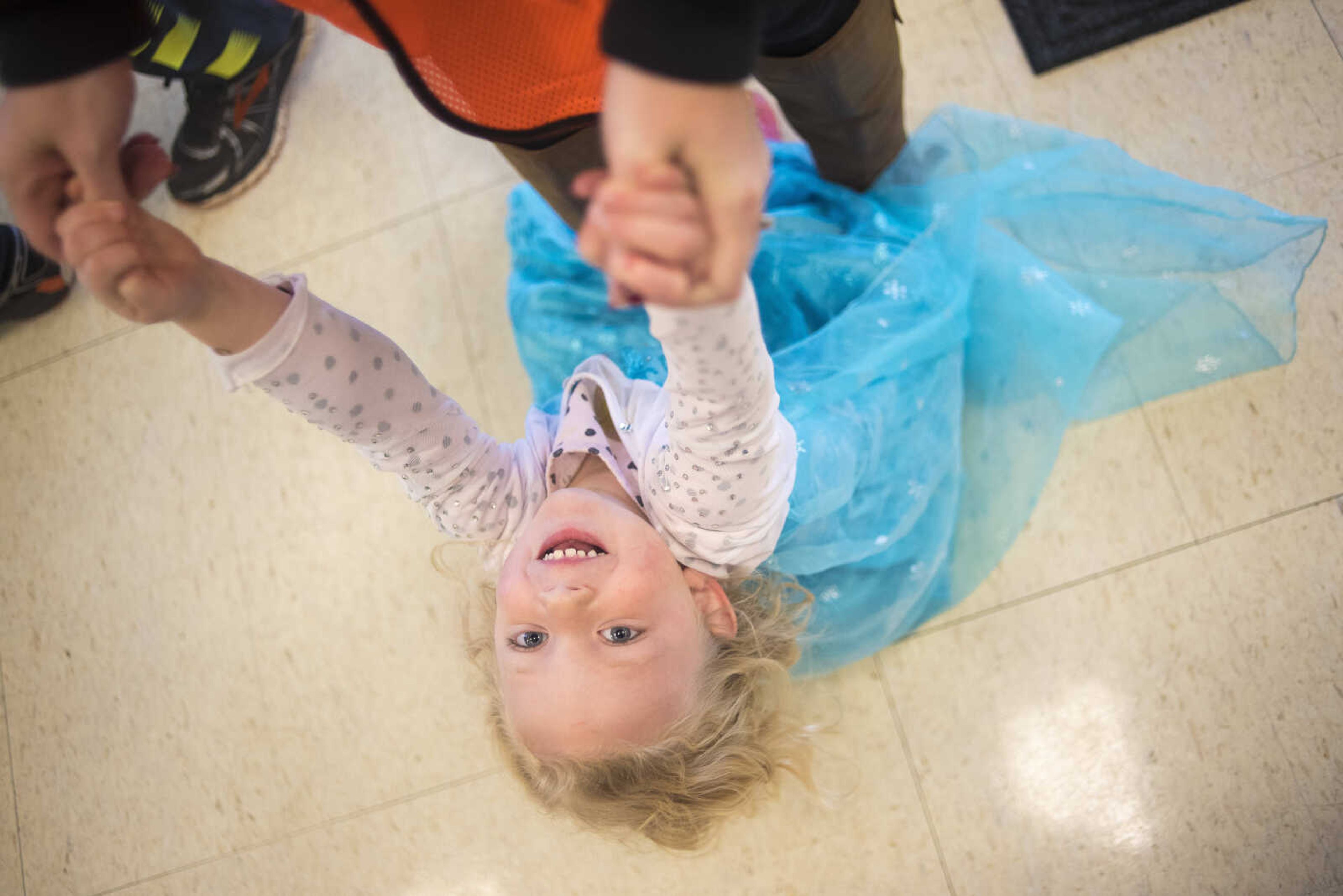 Sophie Pearson, 3, hangs onto her mother Stacy Pearson's arms before the first Ghost and Goblin Gallop 5k race to raise money for the Crossroads Backpack Fair on Saturday, Oct. 28, 2017 in Jackson.