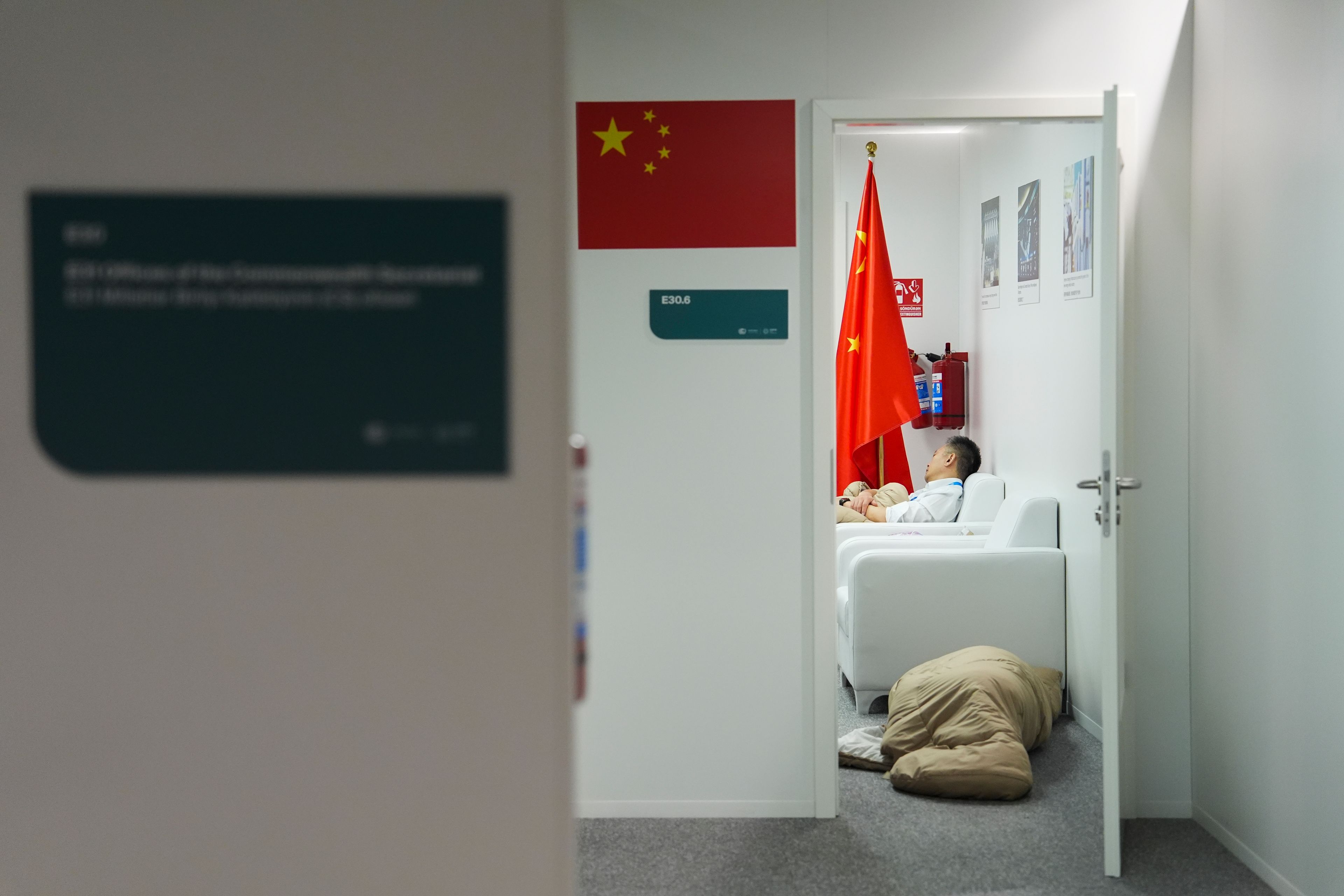 People sleep in the Chinese delegation offices at the COP29 U.N. Climate Summit in the early hours of Saturday, Nov. 23, 2024, in Baku, Azerbaijan. (AP Photo/Joshua A. Bickel)