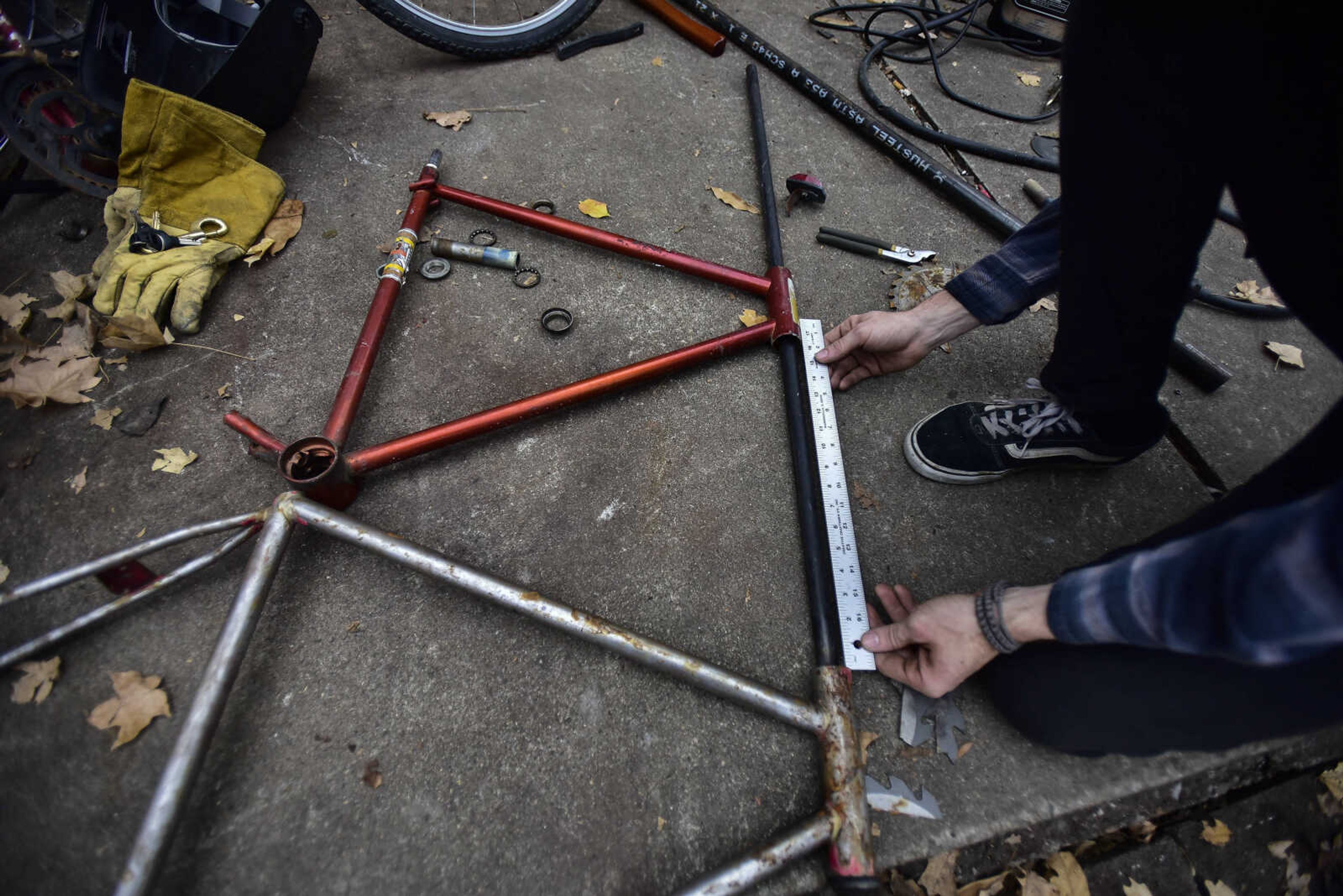 Parker Bond measures out the frame of a bike he is building at his home Thursday, Dec. 21, 2017 in Cape Girardeau.