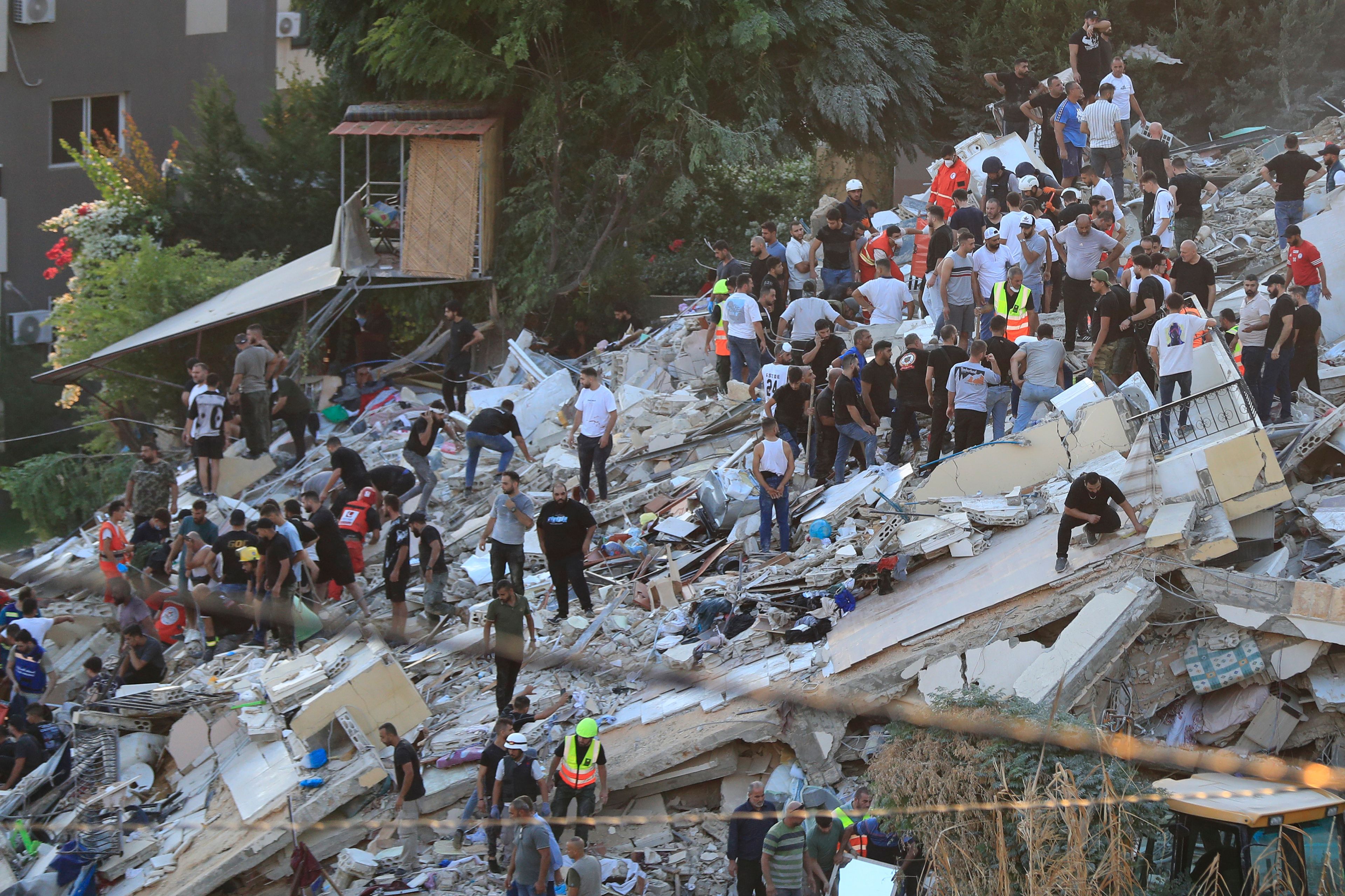 FILE - People and rescue workers search for victims after an Israeli airstrike hit two adjacent buildings, in Ain el-Delb neighborhood east of the southern port city of Sidon, Lebanon, Sunday, Sept. 29, 2024. (AP Photo/Mohammed Zaatari, File)