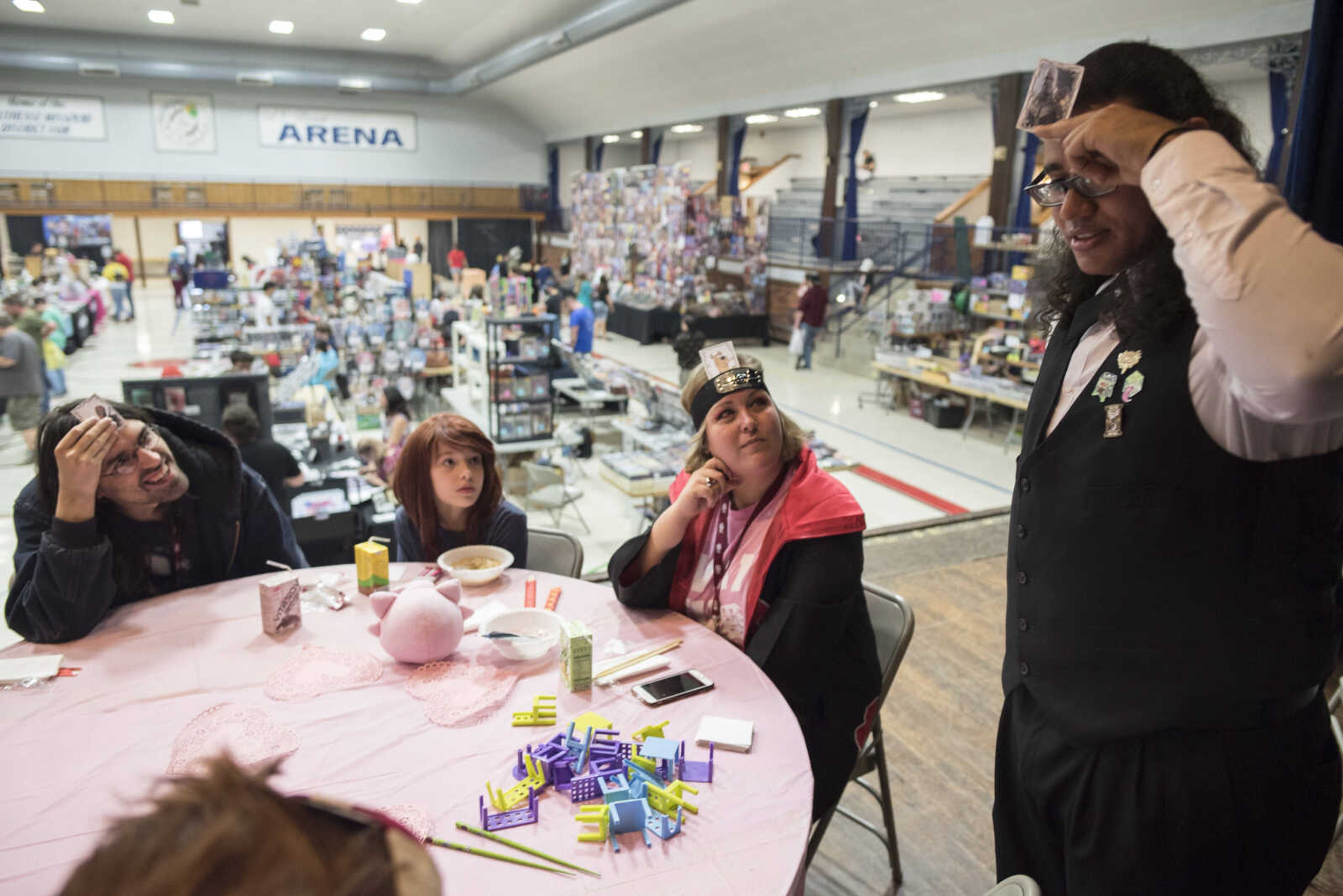 From left, Eric Danz plays a character guessing game with Zelda Deyeso-Danz, dressed as Ochaco Uraraka from My Hero Academia; Joelle Middleman, dressed as Itachi Uchiha from Naruto; and Butler Ambrose while sitting at the La Parfait Maid and Butler Cafe area during the inaugural Cape Anime Con on Sept. 22, 2019, at the Arena Building in Cape Girardeau.